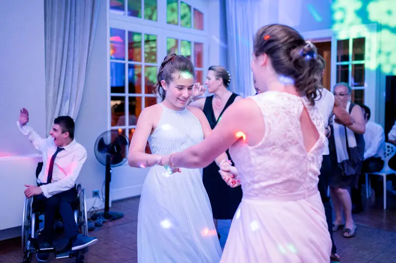 The bride dances with a guest under the party lights