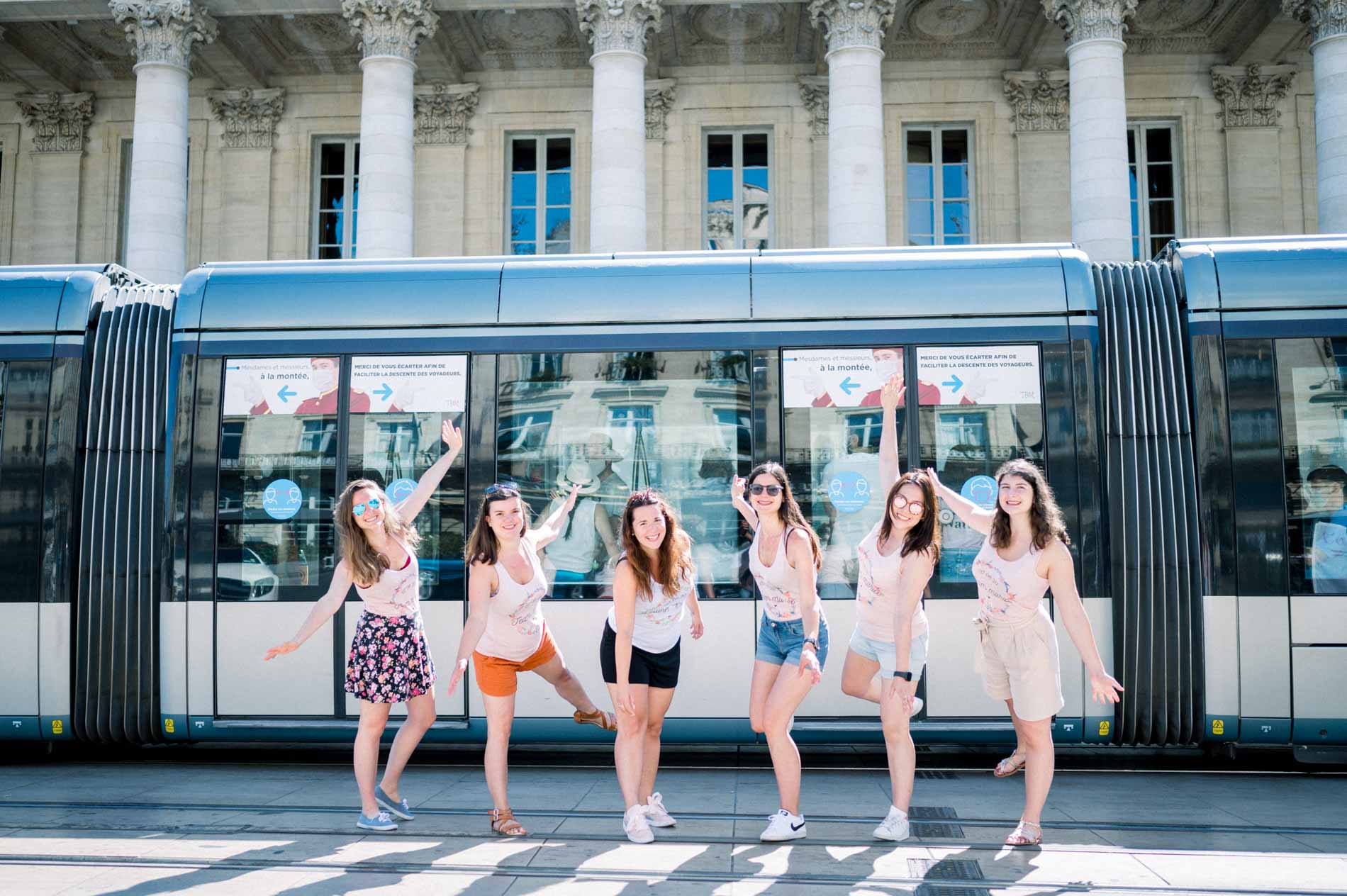 Hen party friends striking a pose in front of a tram in Bordeaux