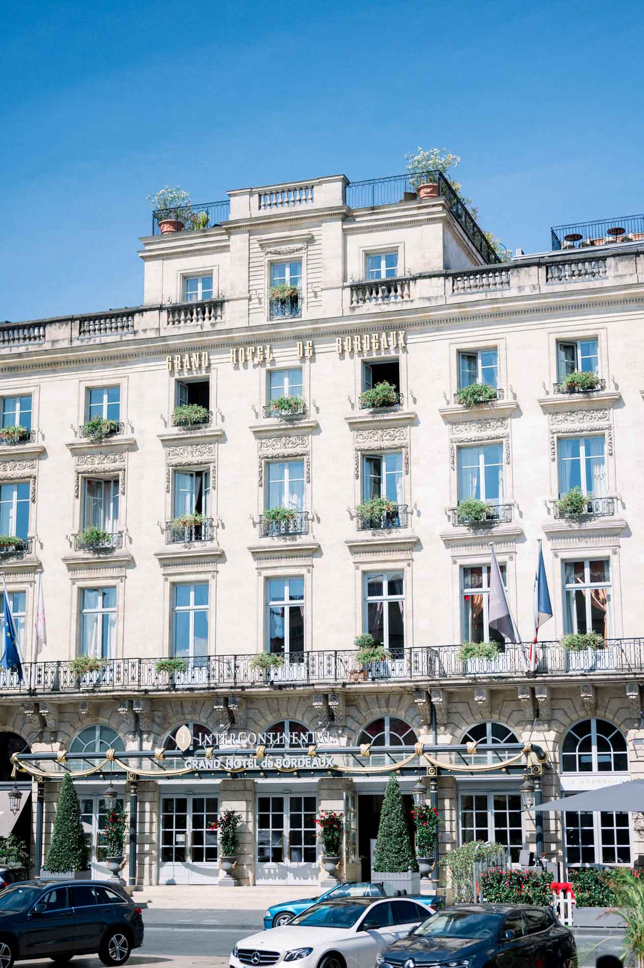 Façade of a grand classical hotel in central Bordeaux under a blue sky