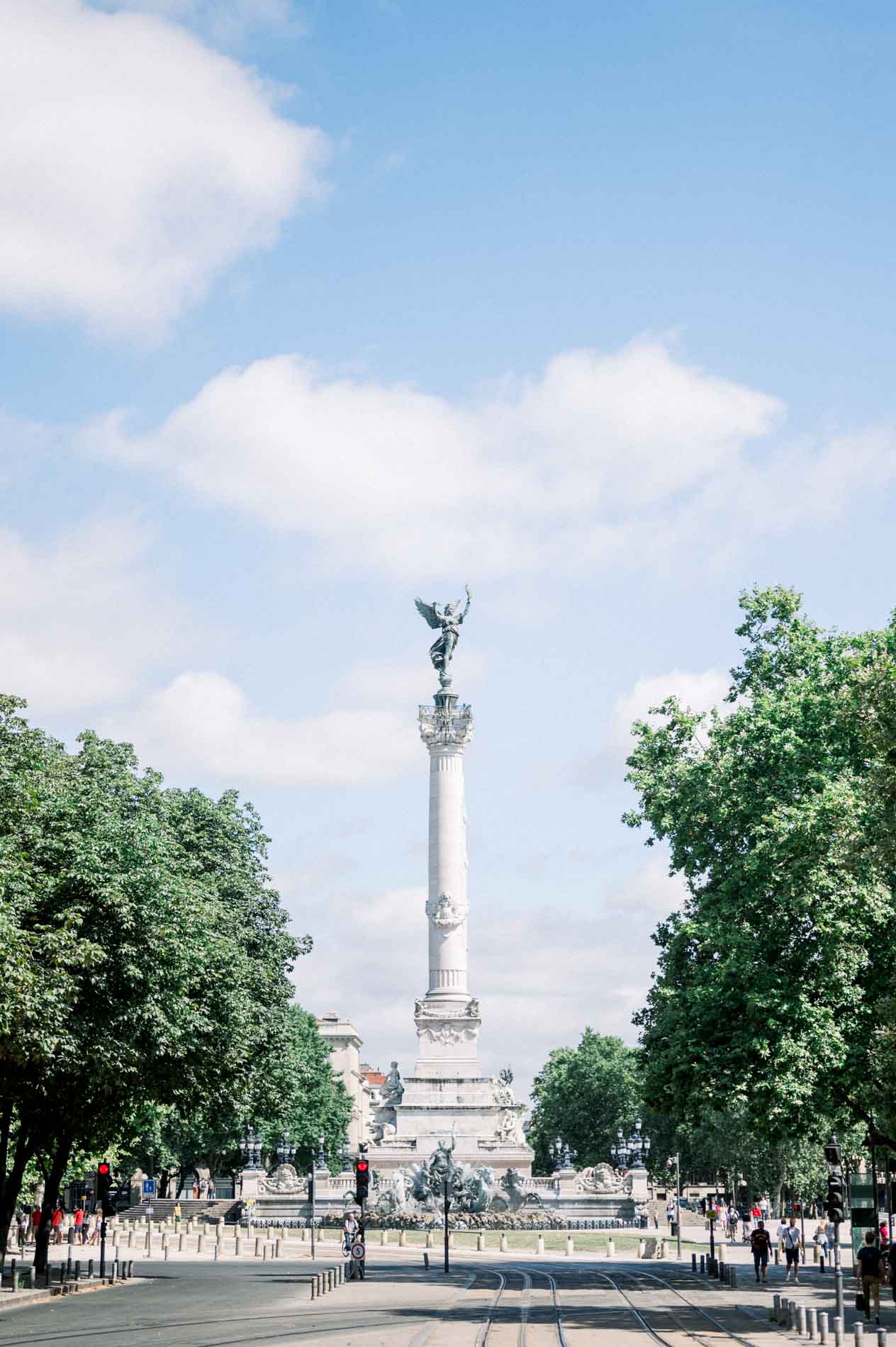 The Girondins monument between the trees under a cloudy sky in Bordeaux