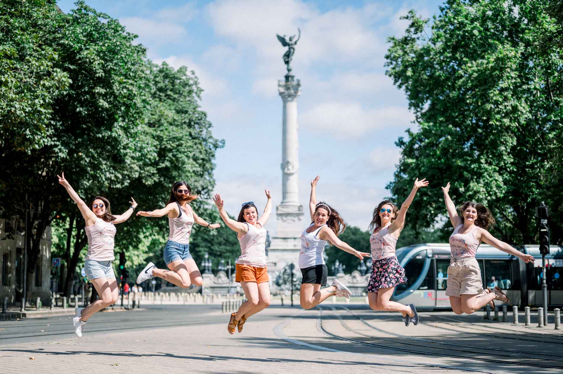Hen party friends jumping for joy before the Girondins monument in Bordeaux