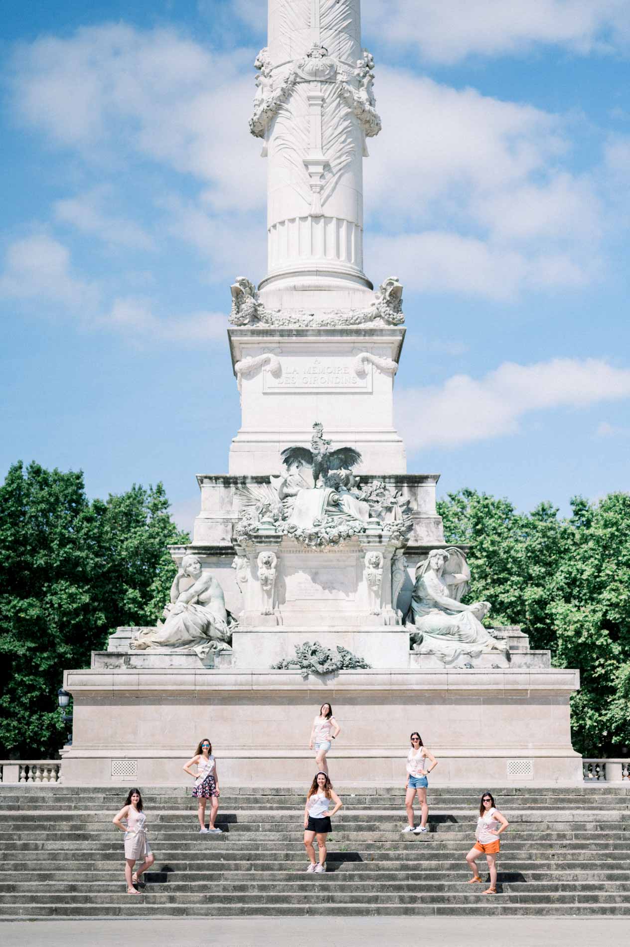 The friends posing on the steps of the Girondins monument, vertical view