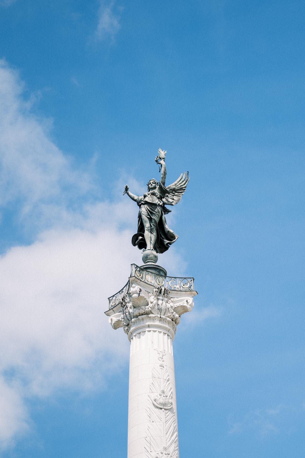 Winged statue atop the Girondins column against the clouds