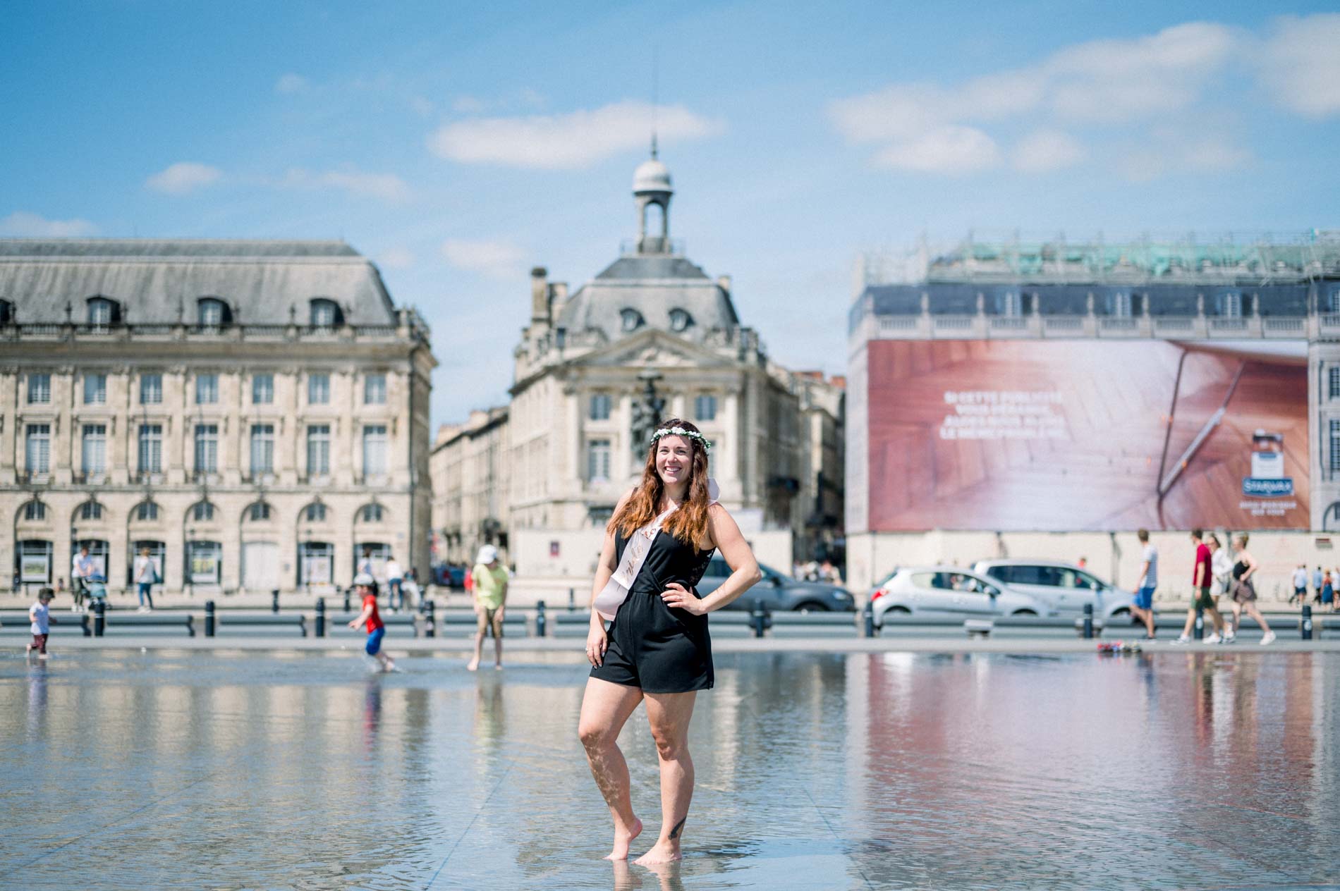 The bride-to-be alone on the water mirror with the Bourse façades behind
