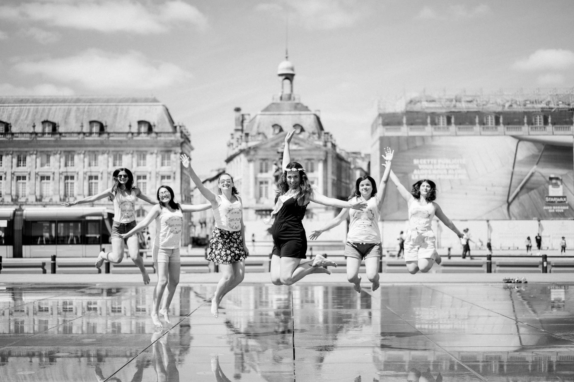 Hen party friends jumping on the Bordeaux water mirror, in black and white