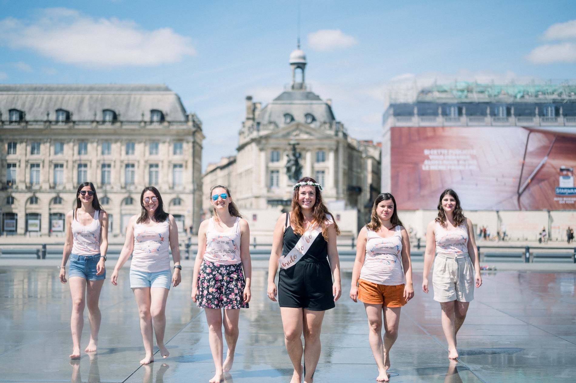 The bride-to-be and her friends walking through the Bordeaux water mirror