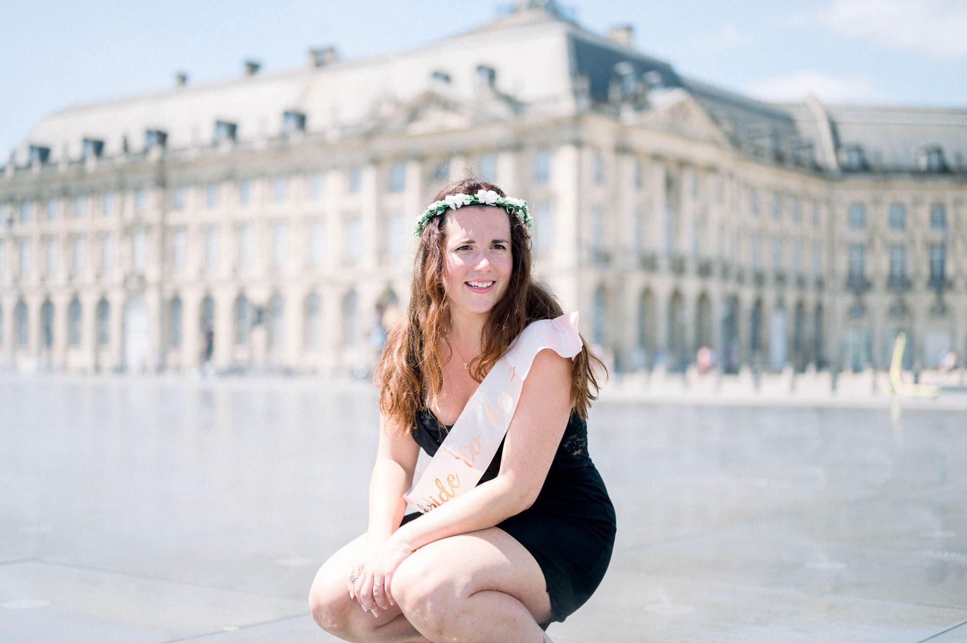The flower-crowned bride-to-be crouching on the Bordeaux water mirror