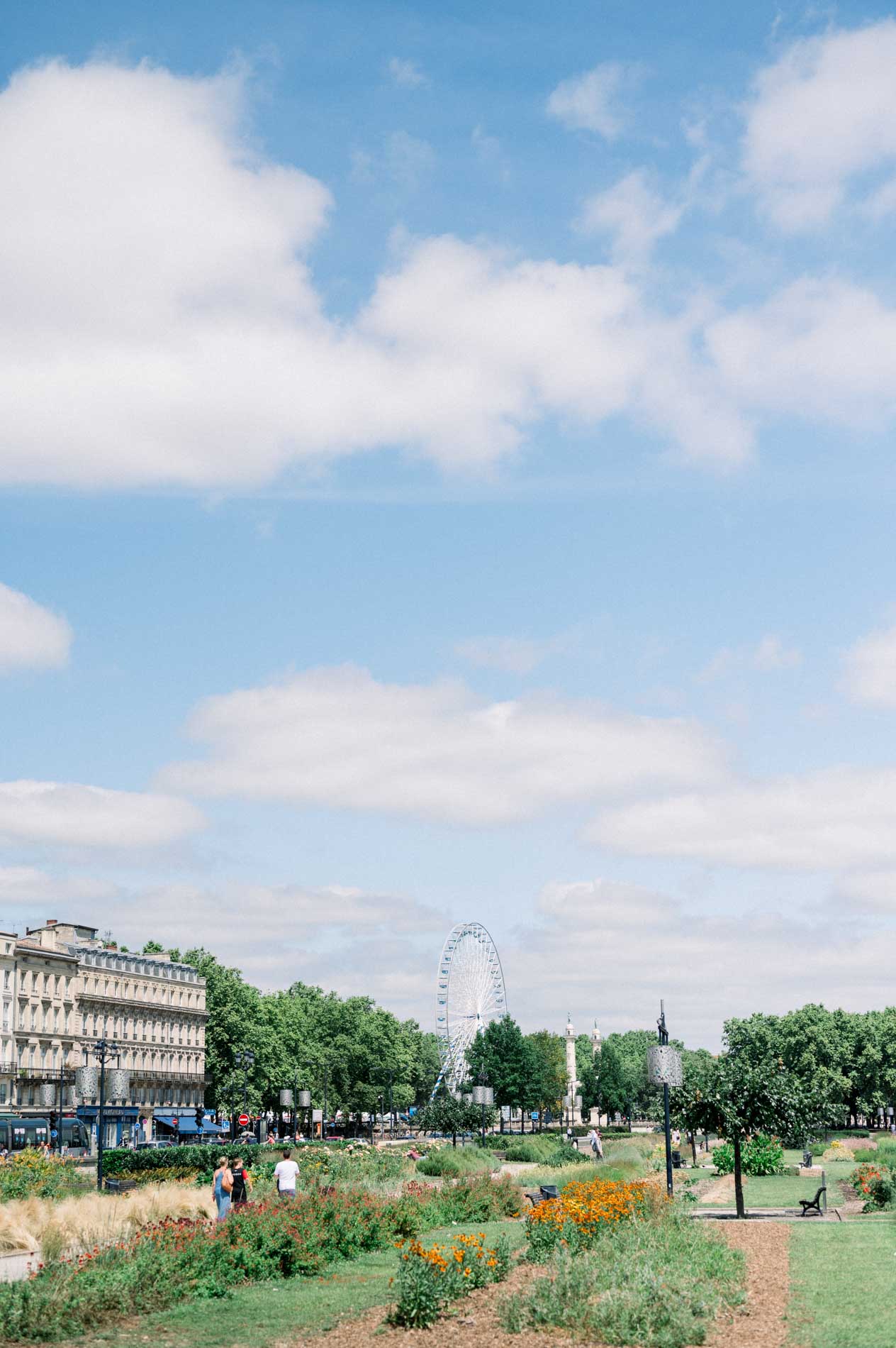 Flowering gardens and Ferris wheel on the Bordeaux quays under a summer sky