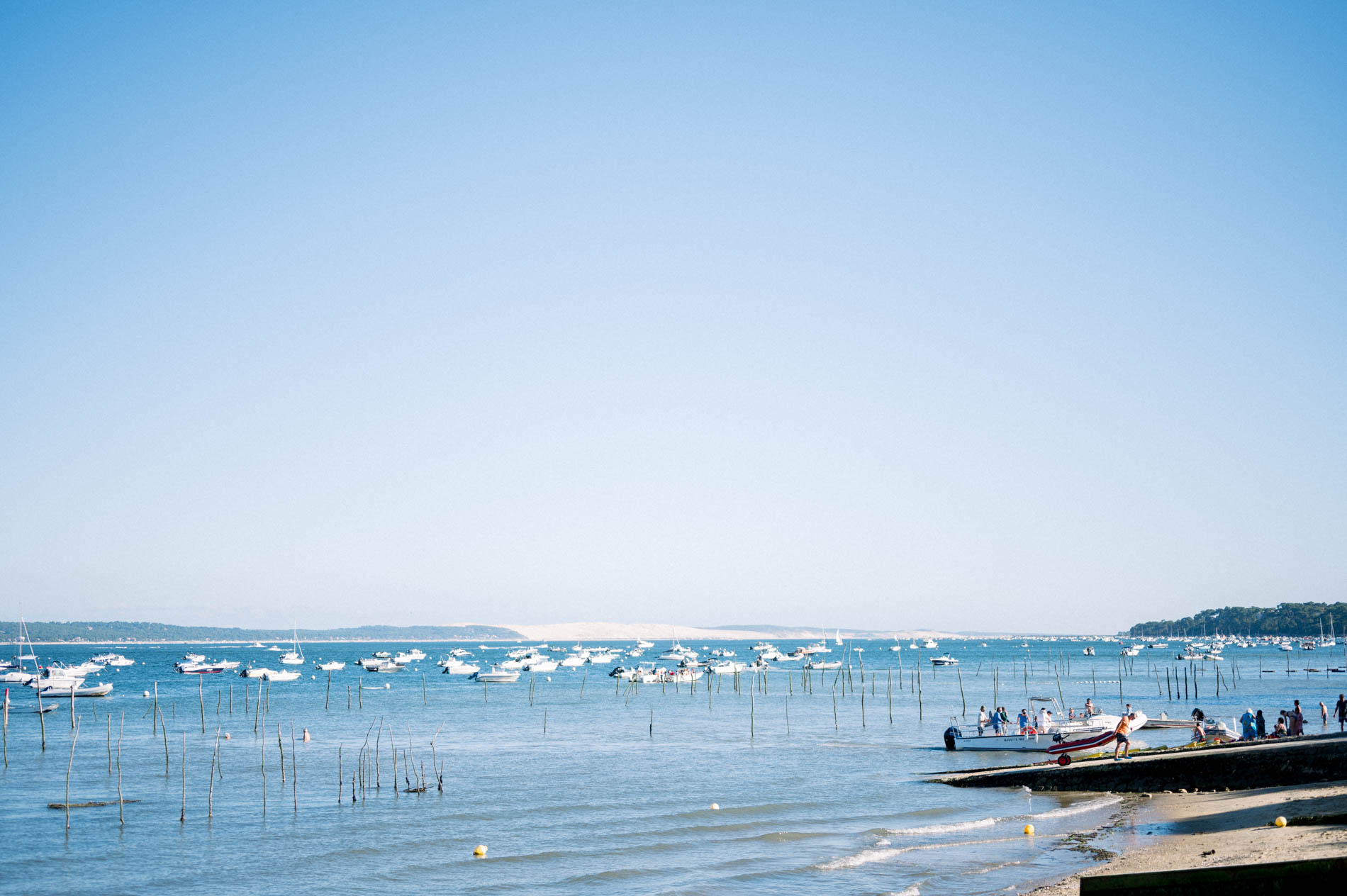 View across Arcachon Bay with its boats and the dune on the horizon