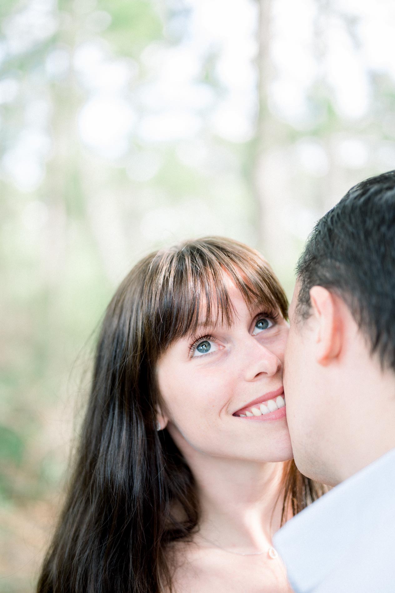 The bright-eyed bride-to-be smiling cheek to cheek with her fiancé