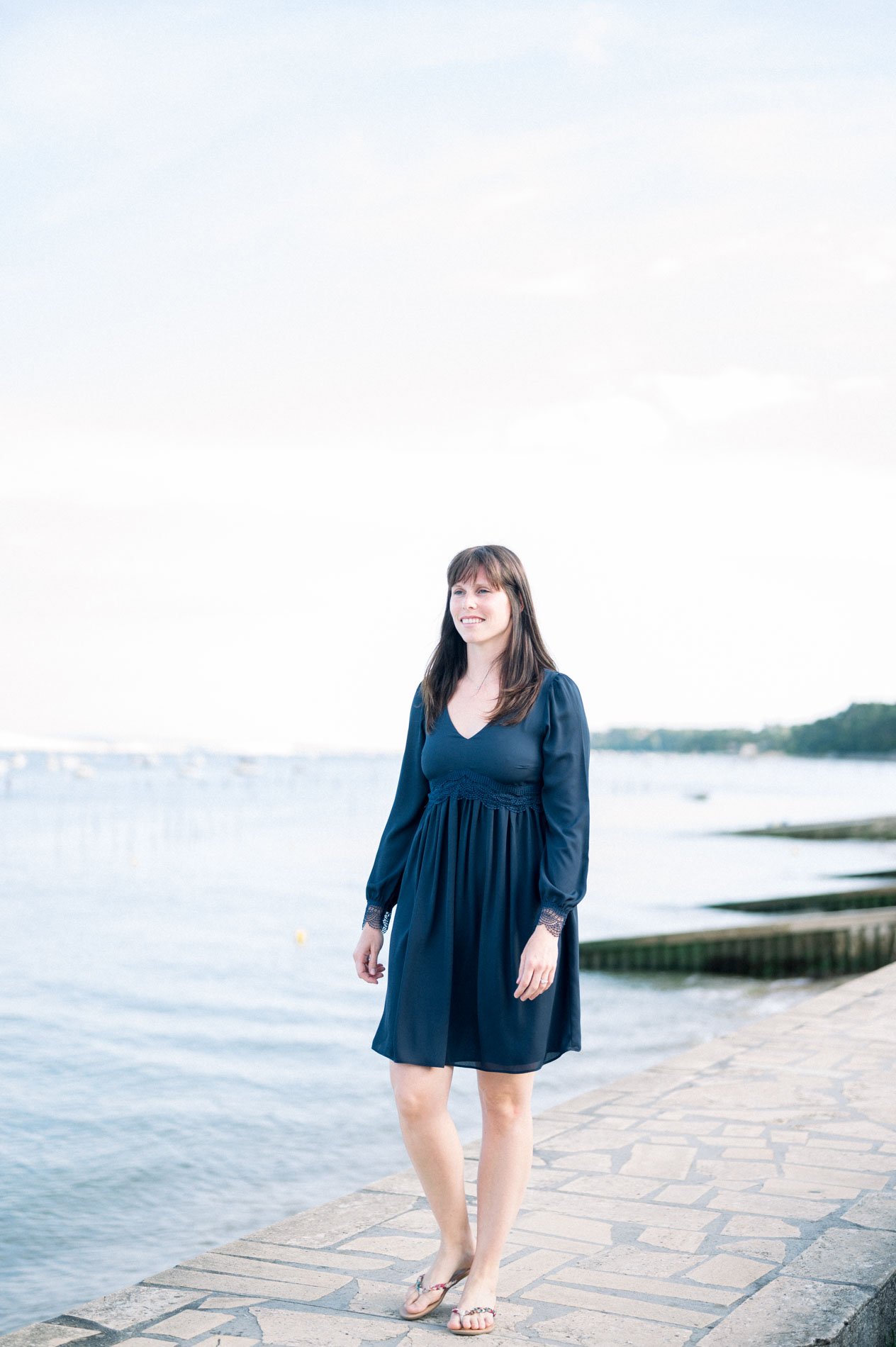 The bride-to-be in a navy dress on a slipway facing Arcachon Bay