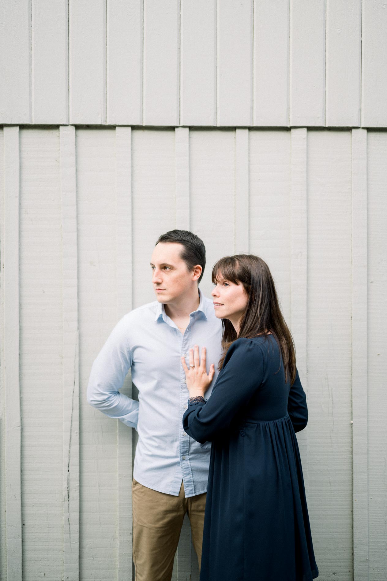 The couple standing in front of a white wooden cabin in the oyster village