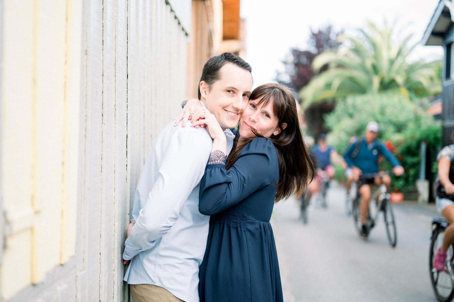 The couple embracing in a lane as cyclists ride past