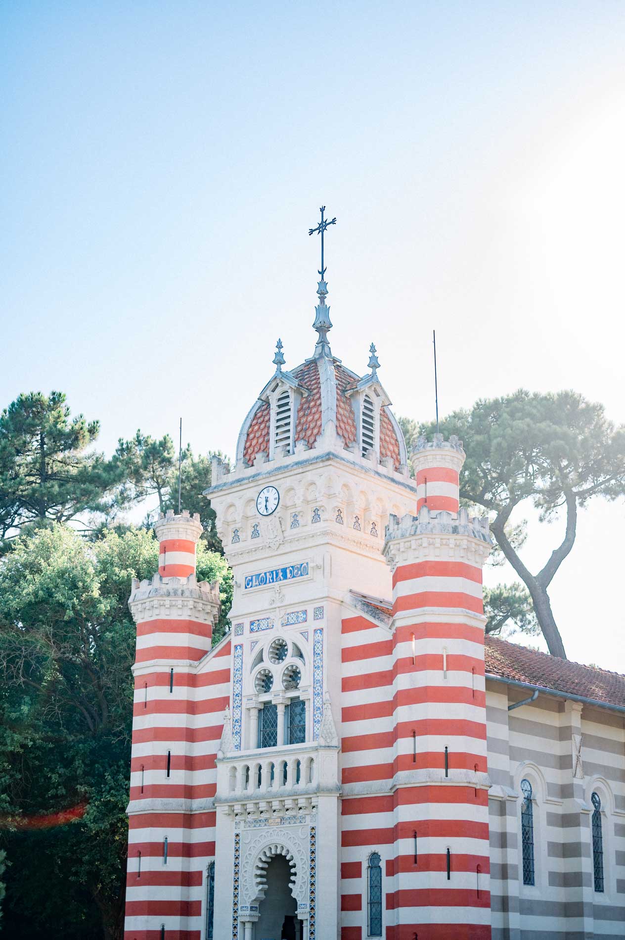 Chapel with red and white striped brickwork and an ornate dome under blue sky