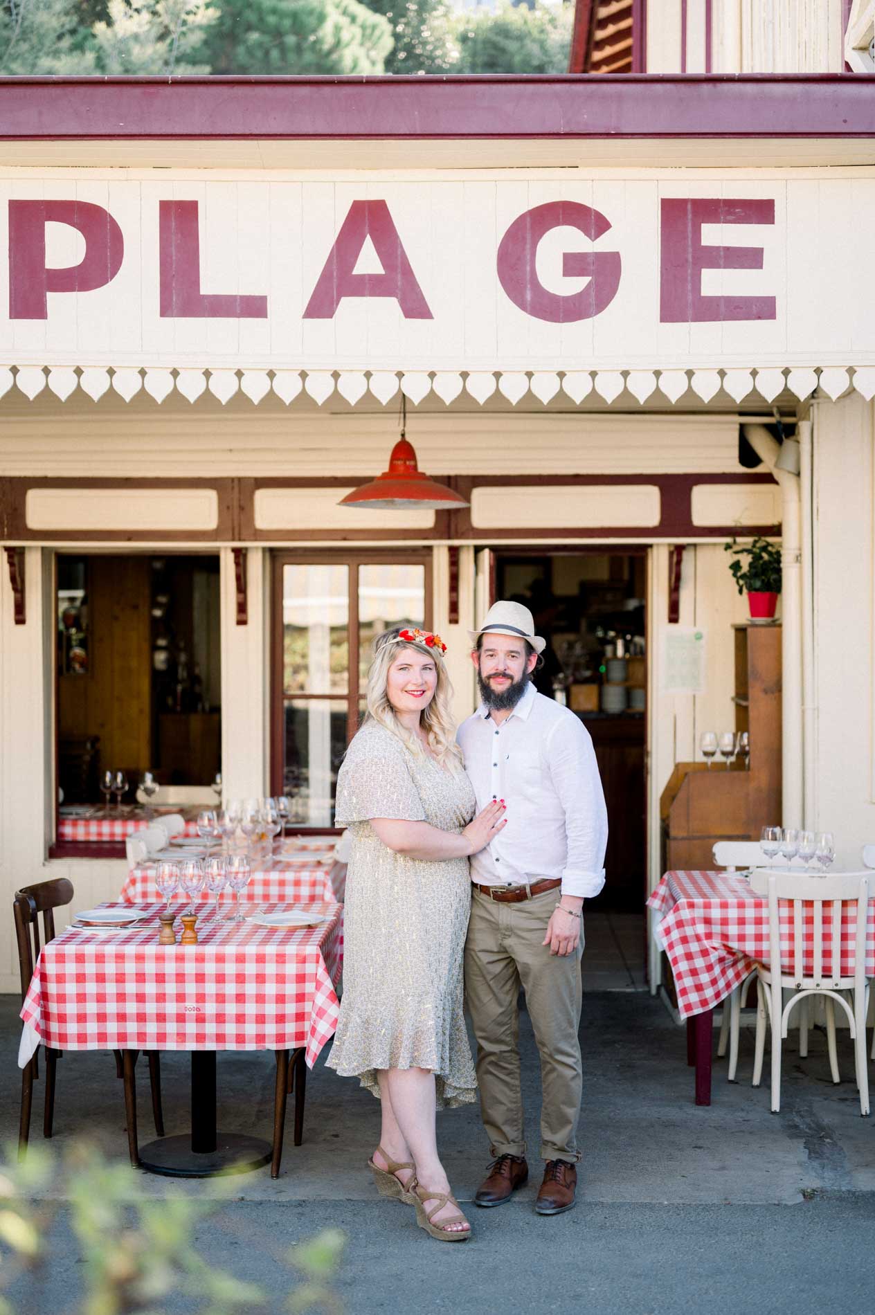 The couple outside a beach restaurant terrace with gingham tablecloths
