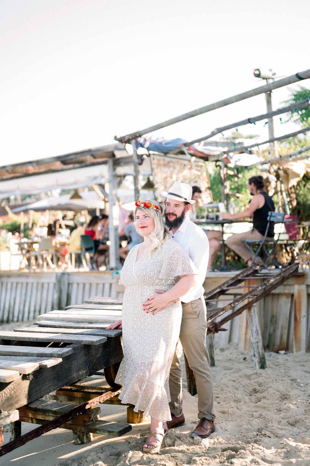The couple on a wooden jetty by a busy oyster hut