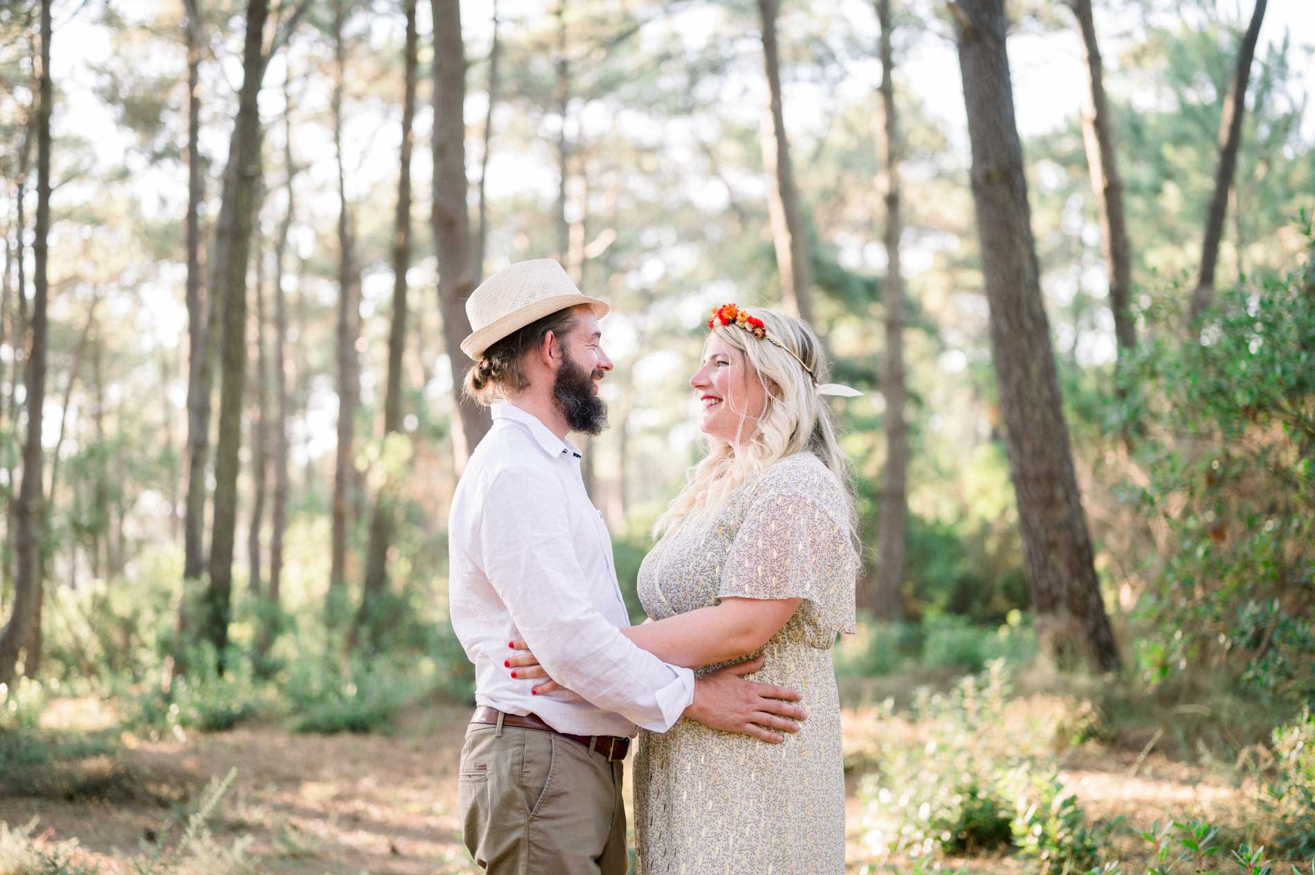 The couple embracing and gazing at each other among maritime pines