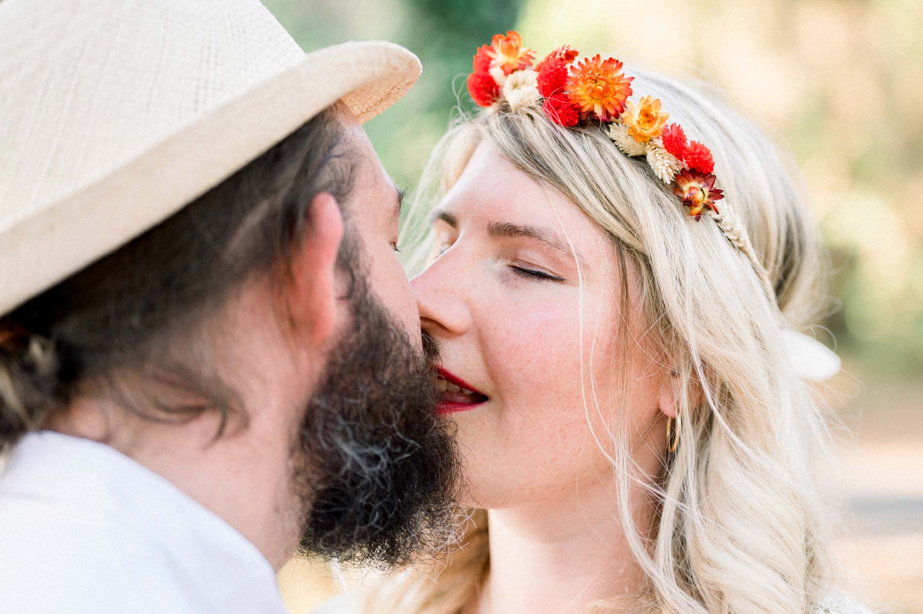 Close-up of the couple cheek to cheek, eyes closed, flower crown in her hair