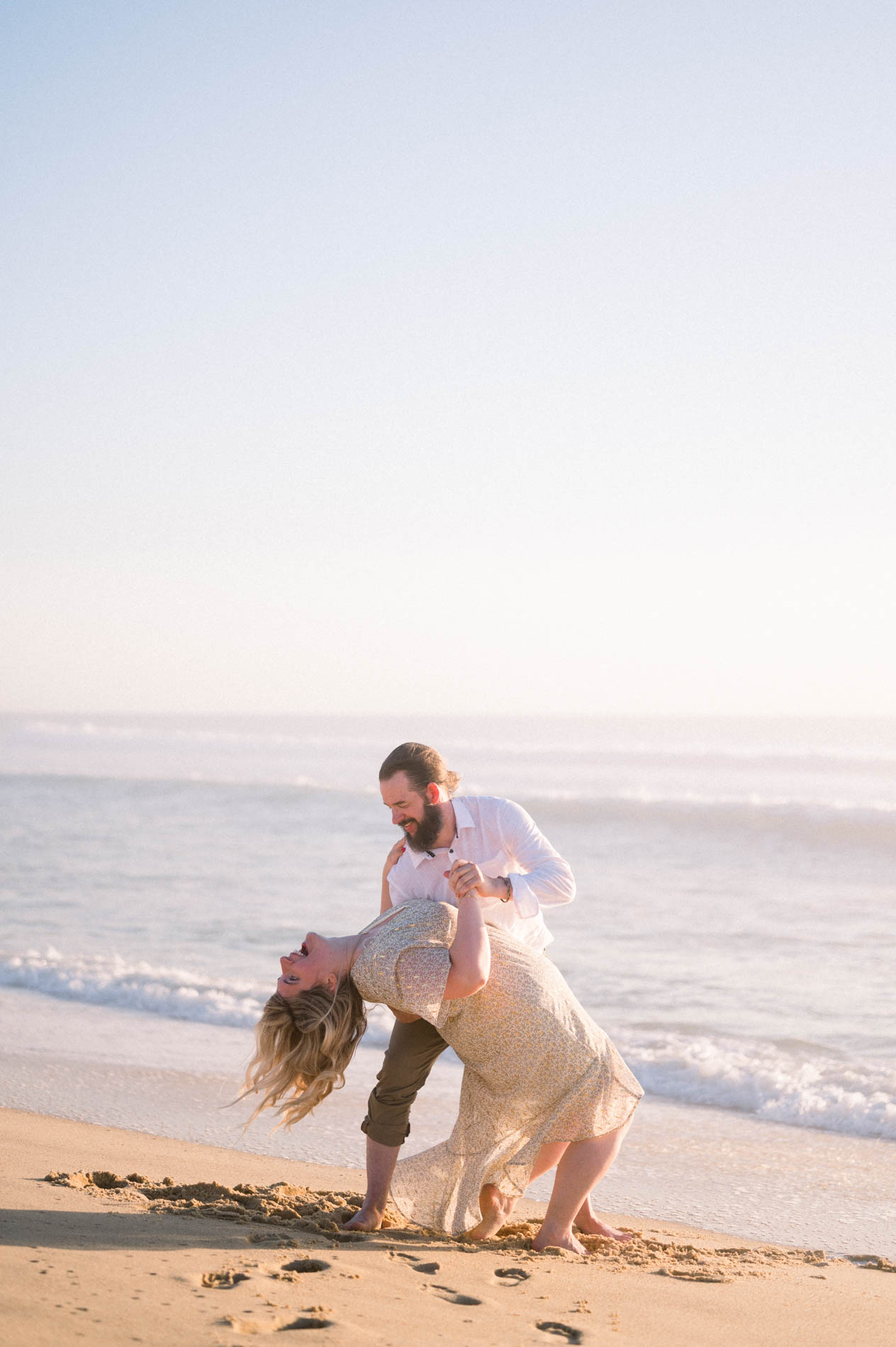 Derek dipping Julie back by the ocean's edge