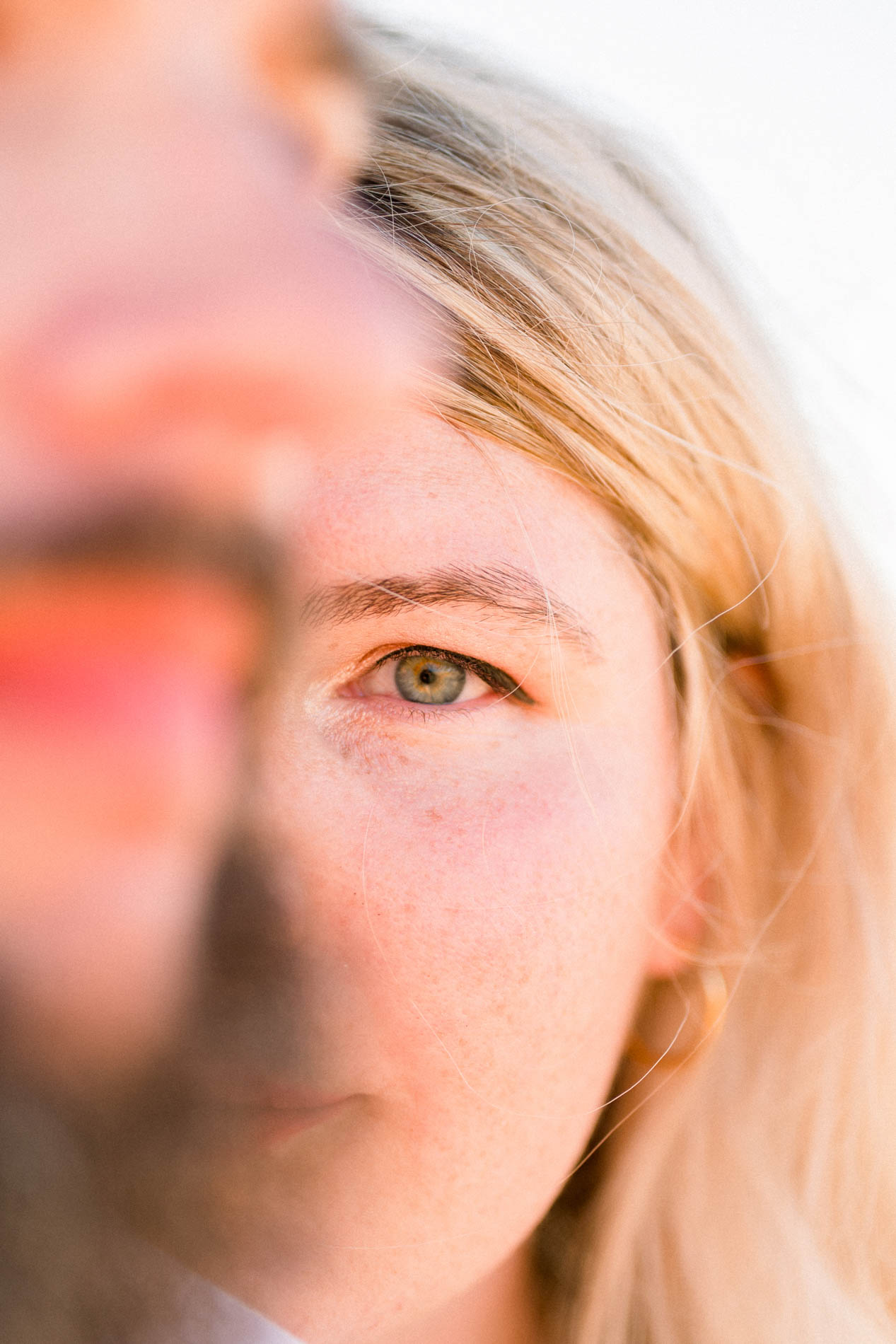 The fiancée's face in golden light, a blurred profile in the foreground