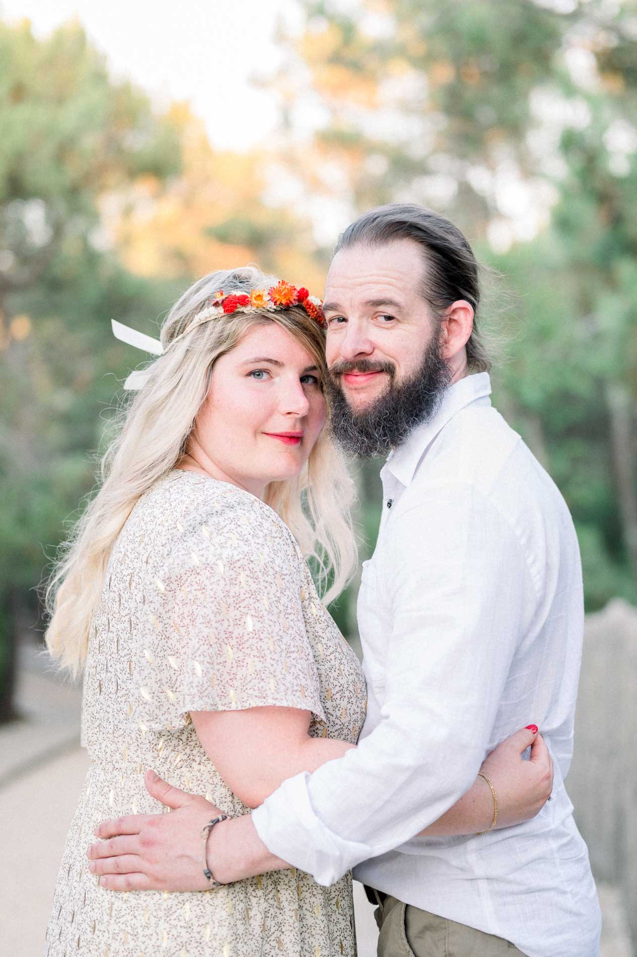 Julie and Derek embracing on the boardwalk, flowers in her hair