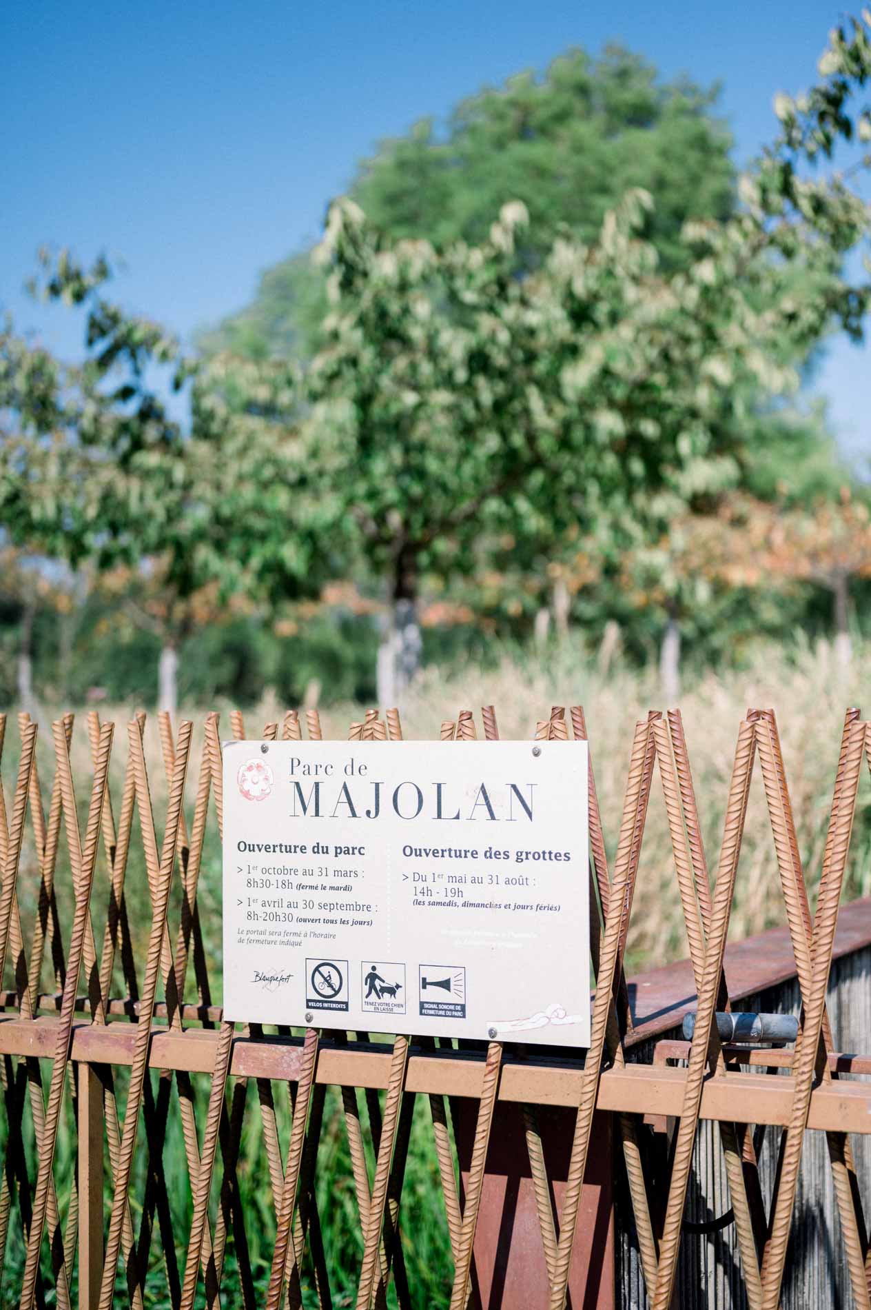 Entrance sign of Parc Majolan behind a rusty iron fence