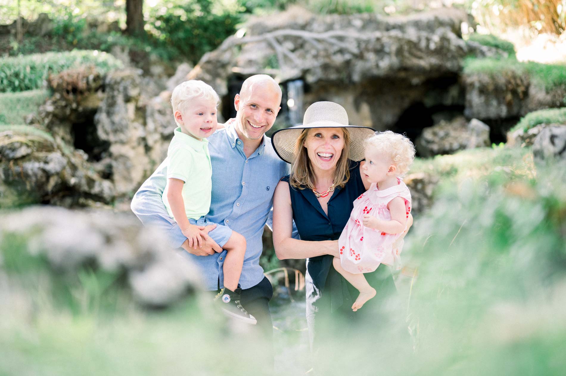 Family portrait of the parents and two children by the rocks of Parc Majolan
