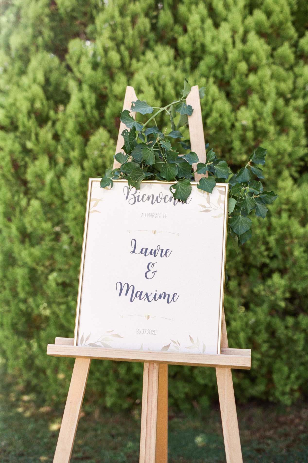 Chevalet avec panneau de bienvenue du mariage décoré de feuillage au Domaine de Larchey