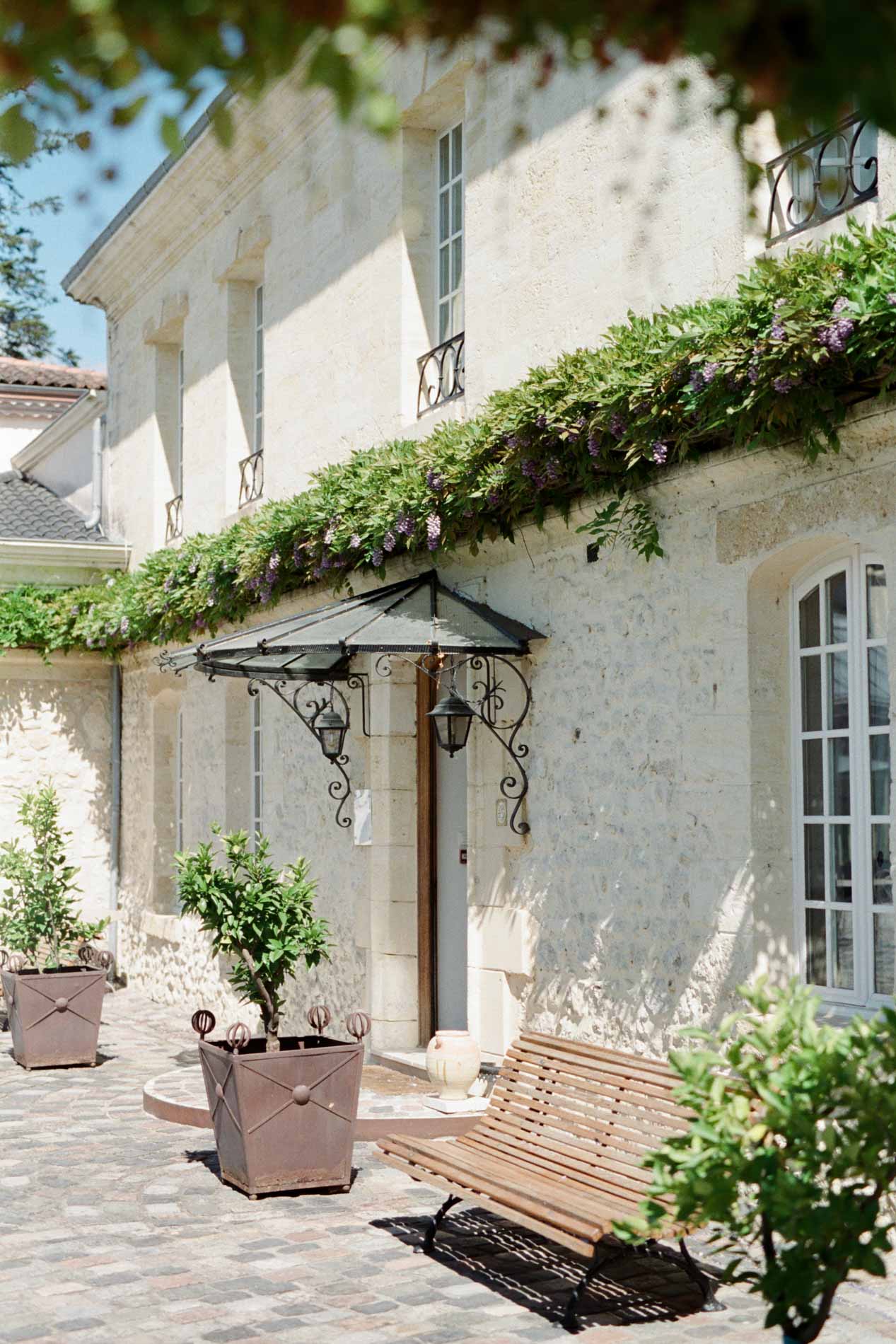 Cour pavée et entrée fleurie de la maison de maître du Domaine de Larchey