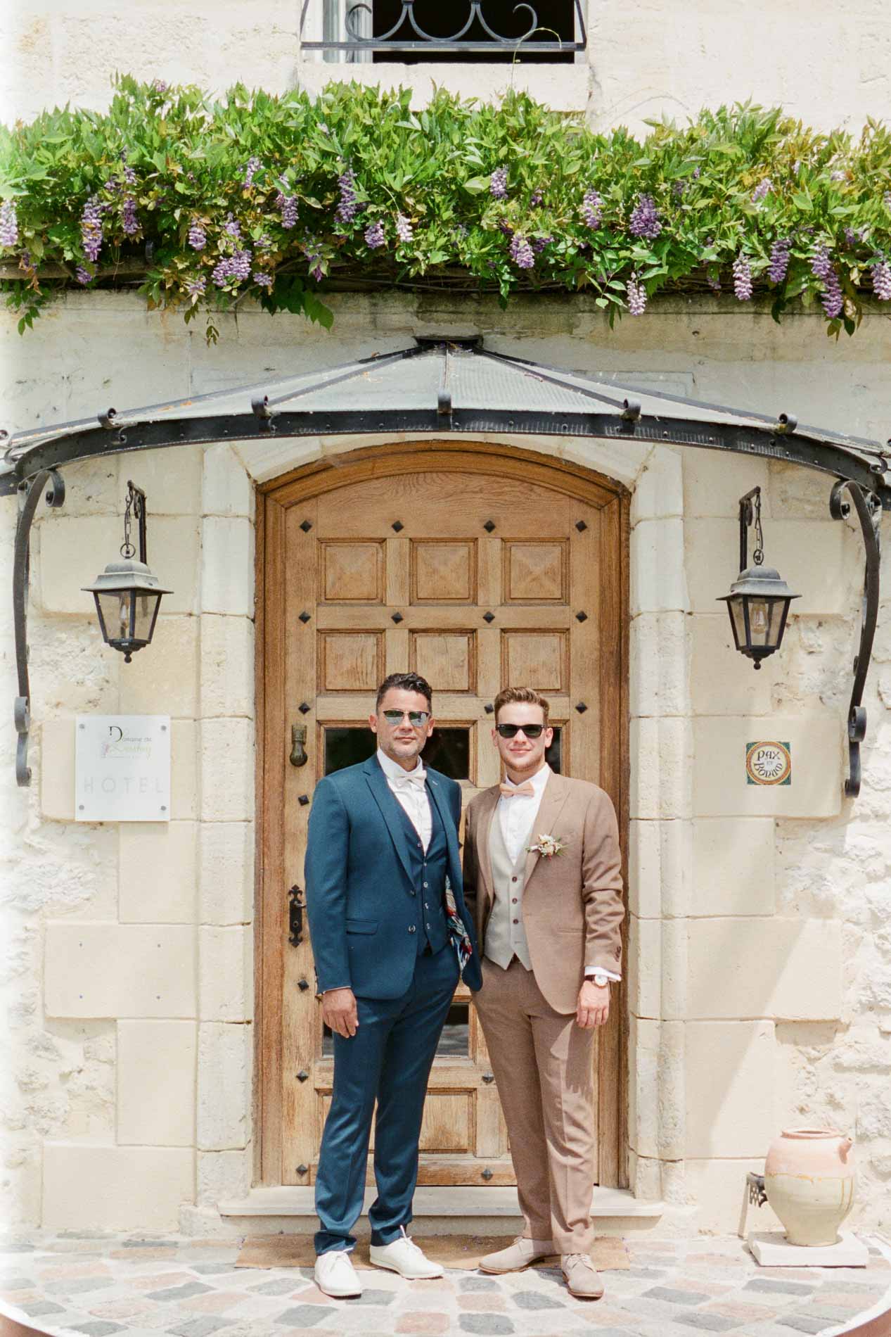 Le marié et son témoin devant la porte d'entrée du Domaine de Larchey