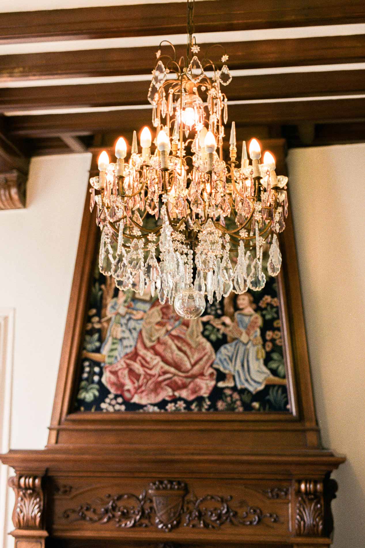 Lustre en cristal et tapisserie au-dessus de la cheminée de la salle des mariages
