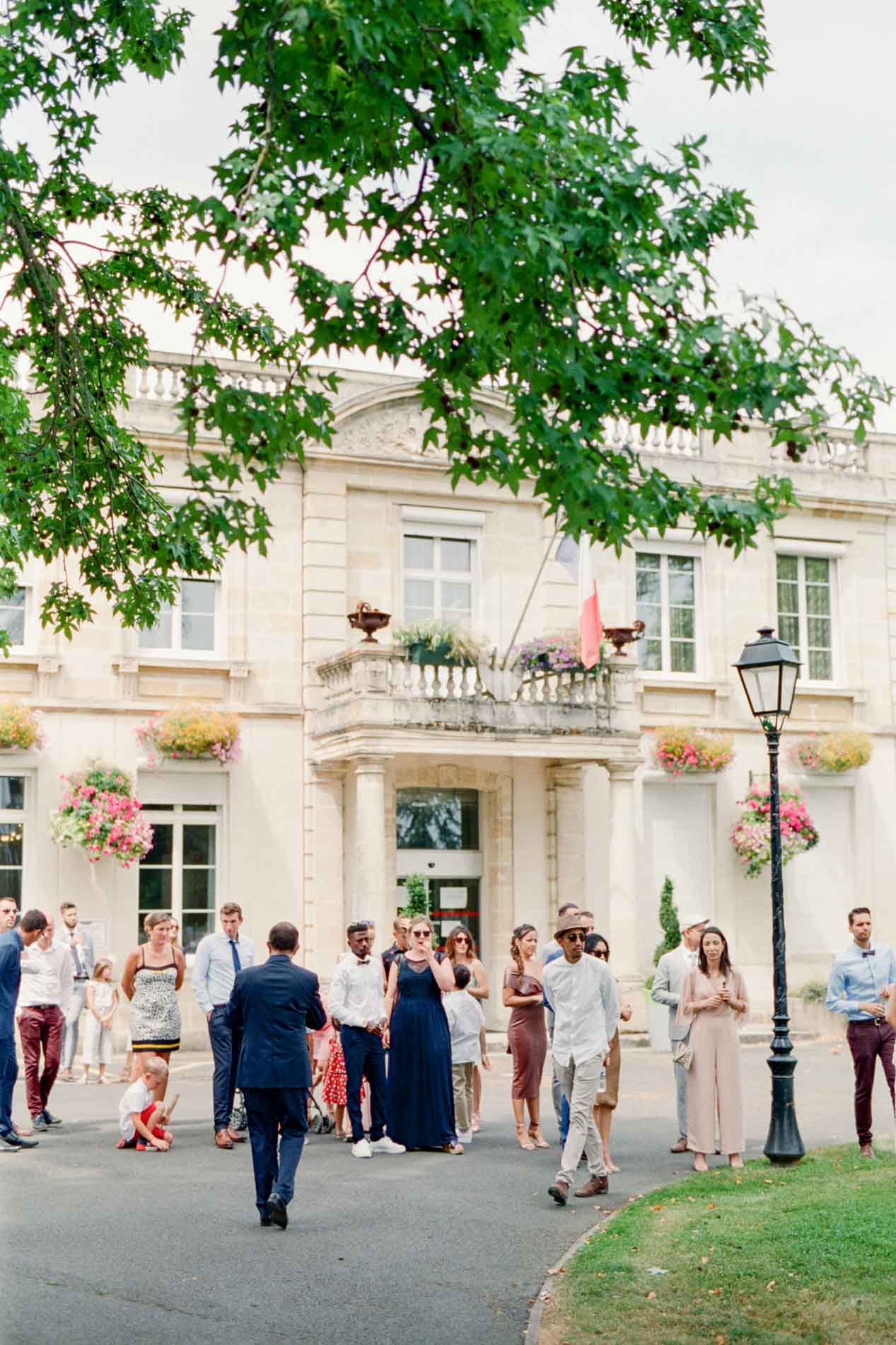 Les invités attendent les mariés devant l'hôtel de ville fleuri de Villenave-d'Ornon
