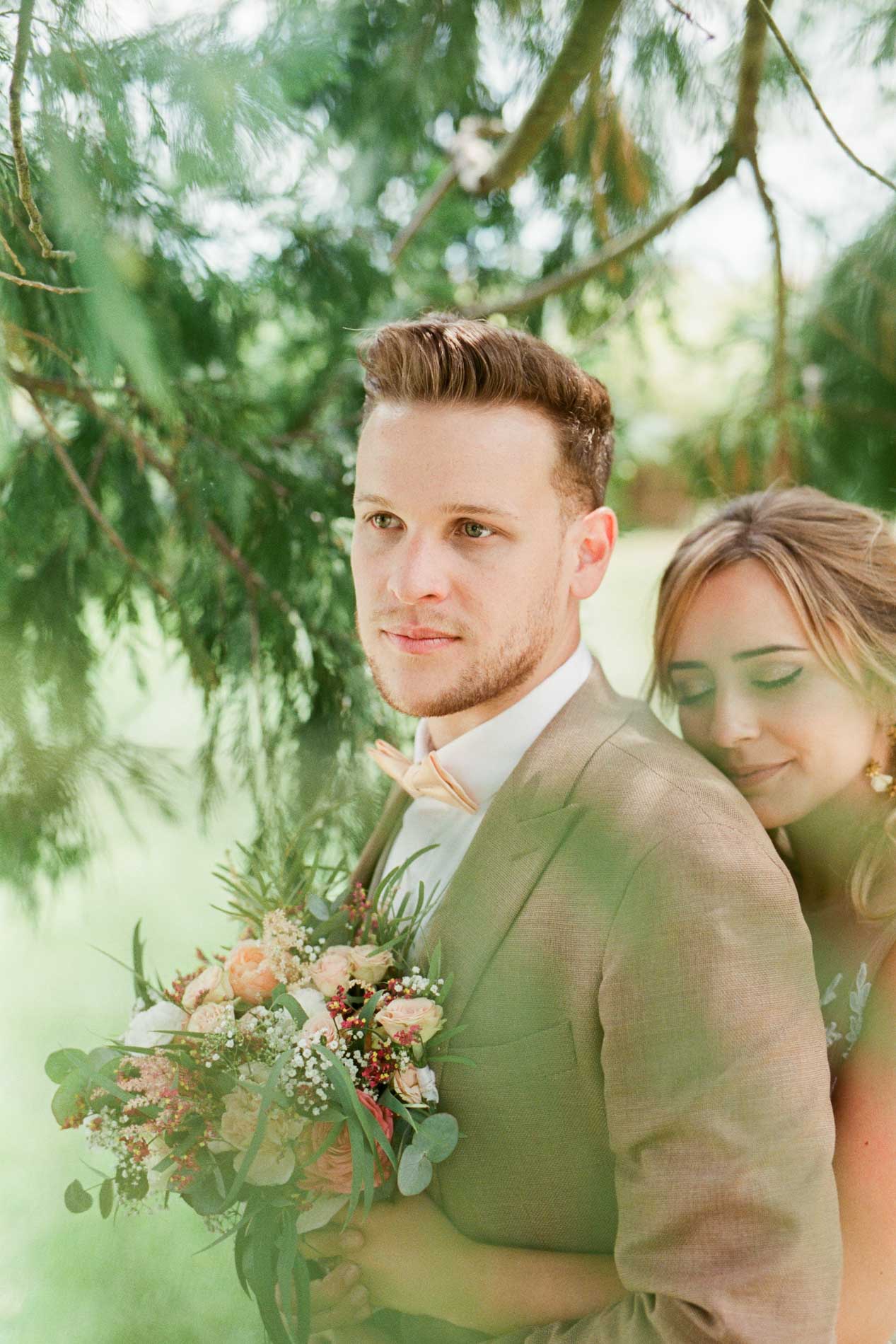 Le marié regarde au loin, la mariée appuyée contre son épaule