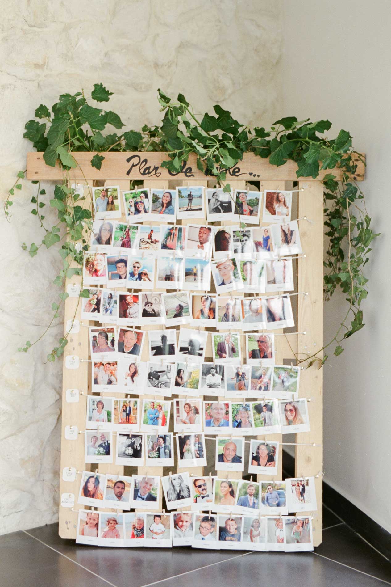 Plan de table en photos Polaroid sur une palette ornée de lierre