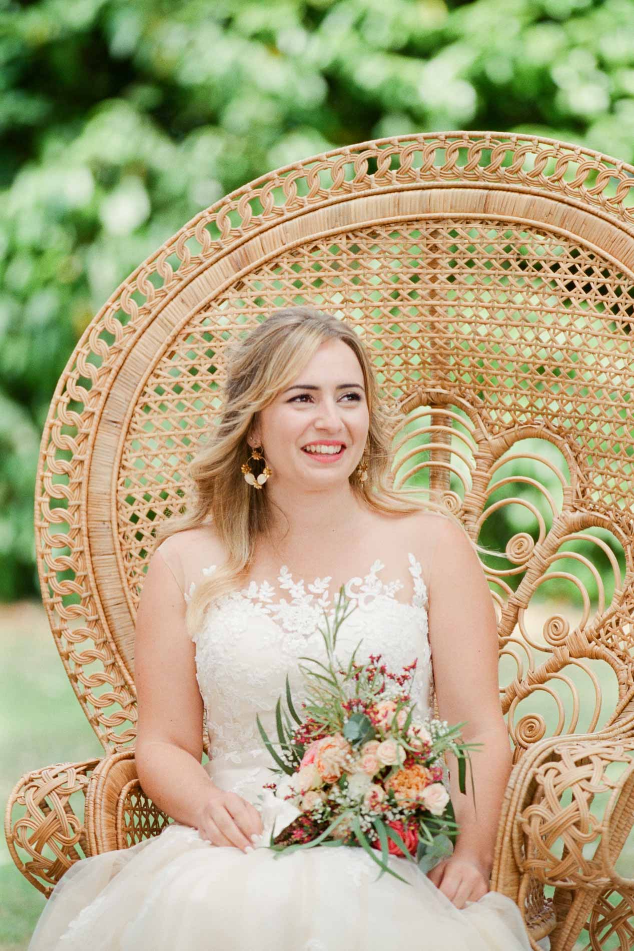 La mariée assise dans un fauteuil en rotin pendant la cérémonie laïque
