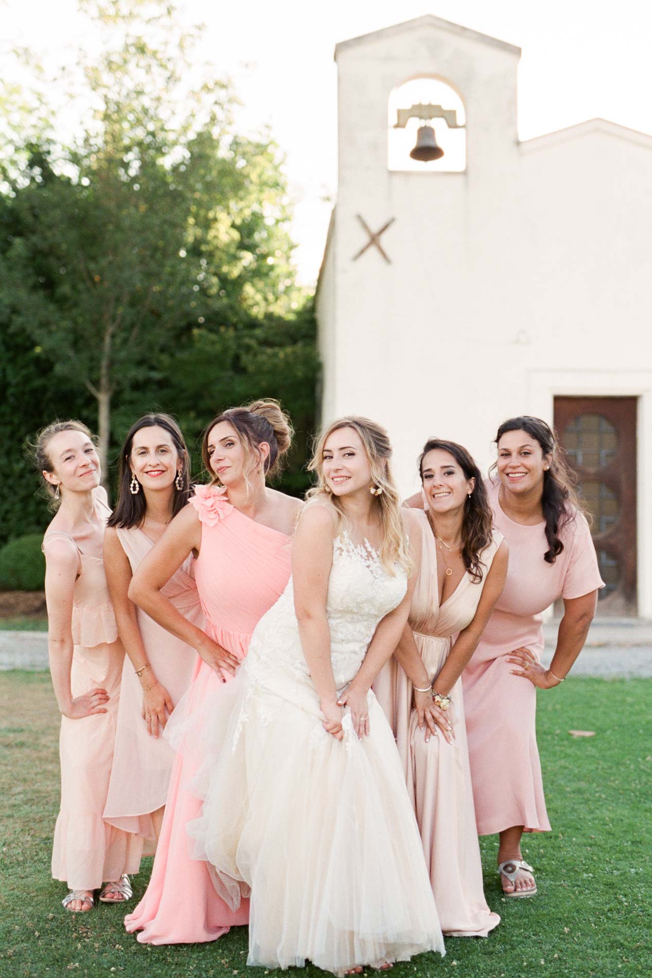 La mariée et ses demoiselles d'honneur en rose devant la chapelle du Domaine de Larchey
