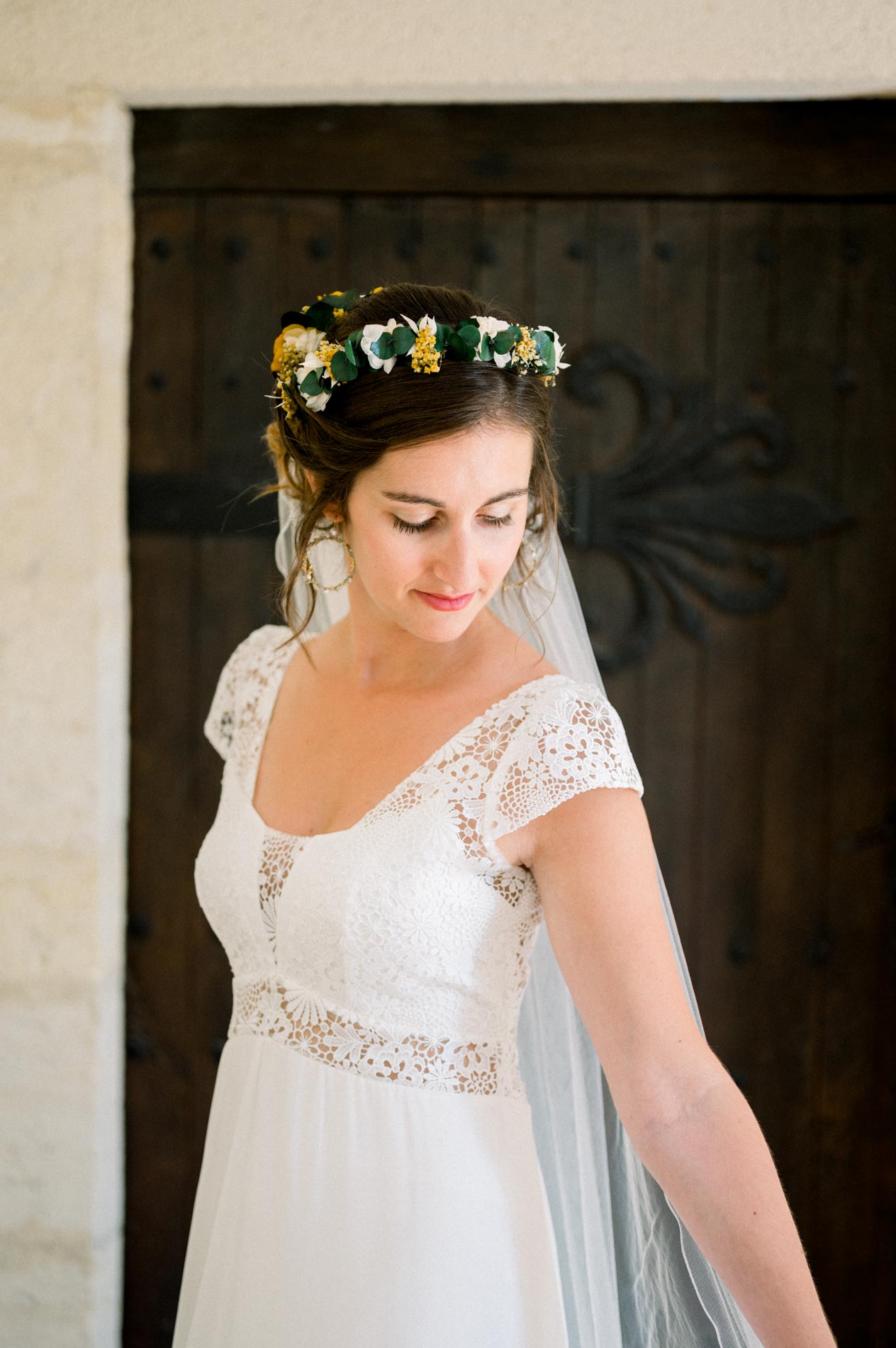 Bride looking down, with a yellow and blue flower crown in her hair