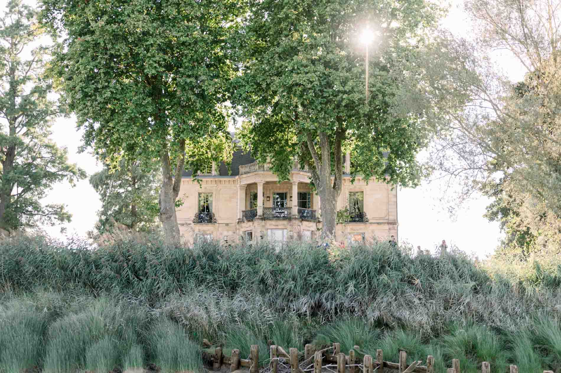 Château Grattequina glimpsed through the trees from the Garonne