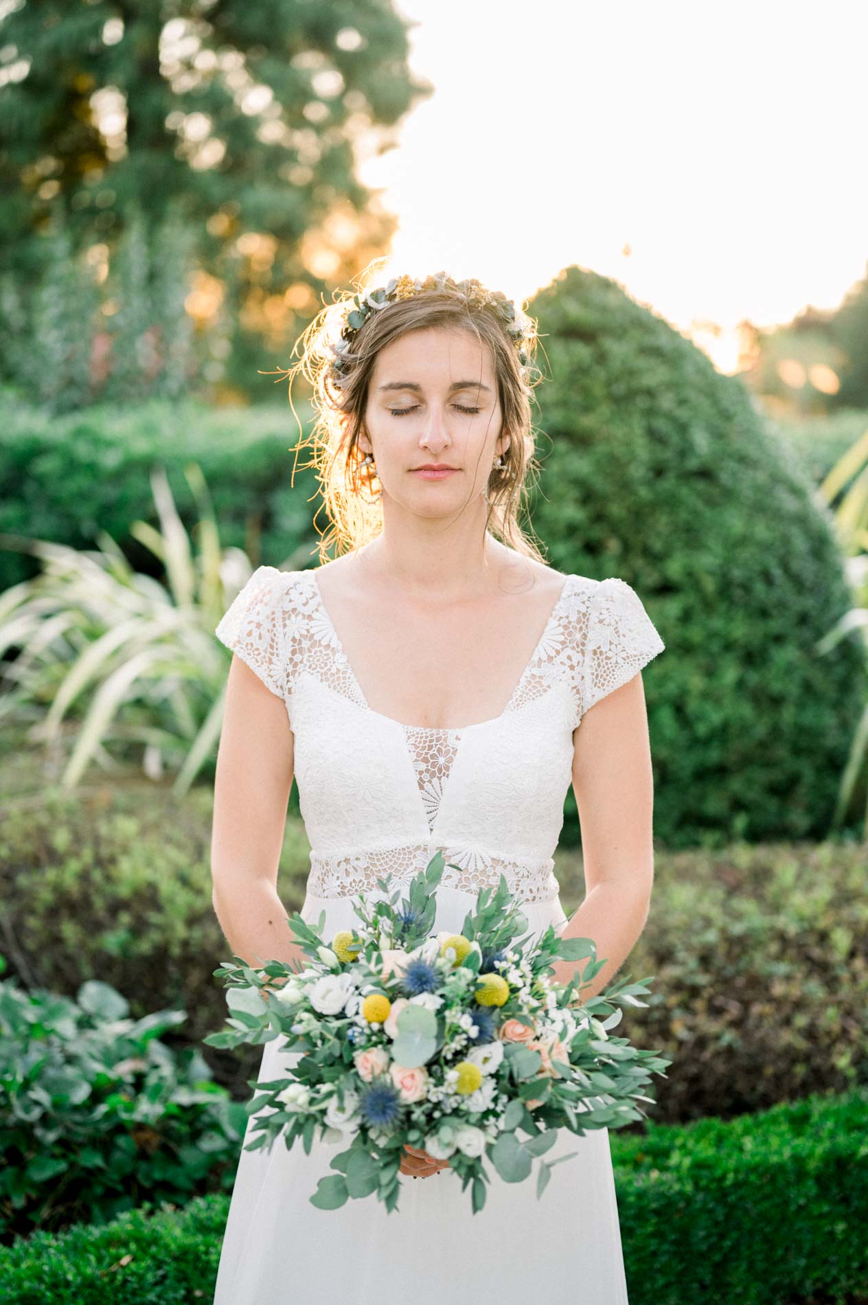 Bride with eyes closed holding her white and blue bouquet