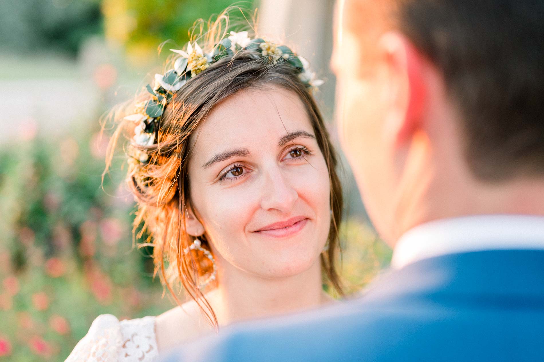 Smiling bride gazing at the groom, flower crown in her hair