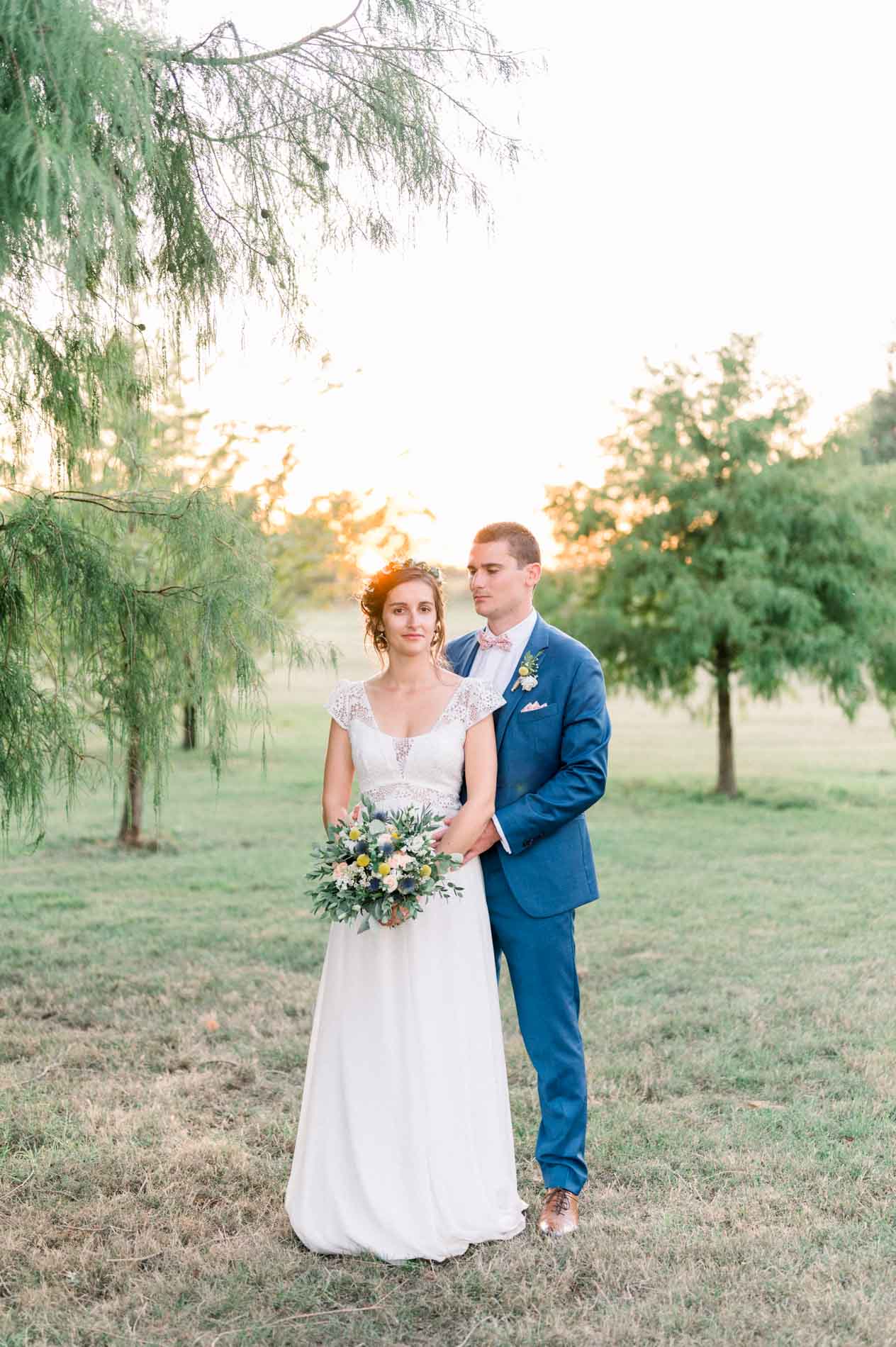 The bride and groom in the château's wooded park in the evening light