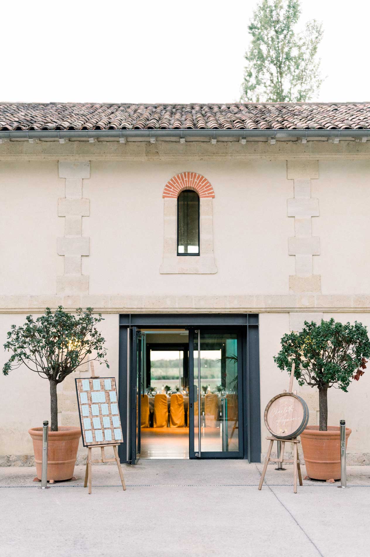 Entrance to the reception hall at Château Grattequina with potted olive trees