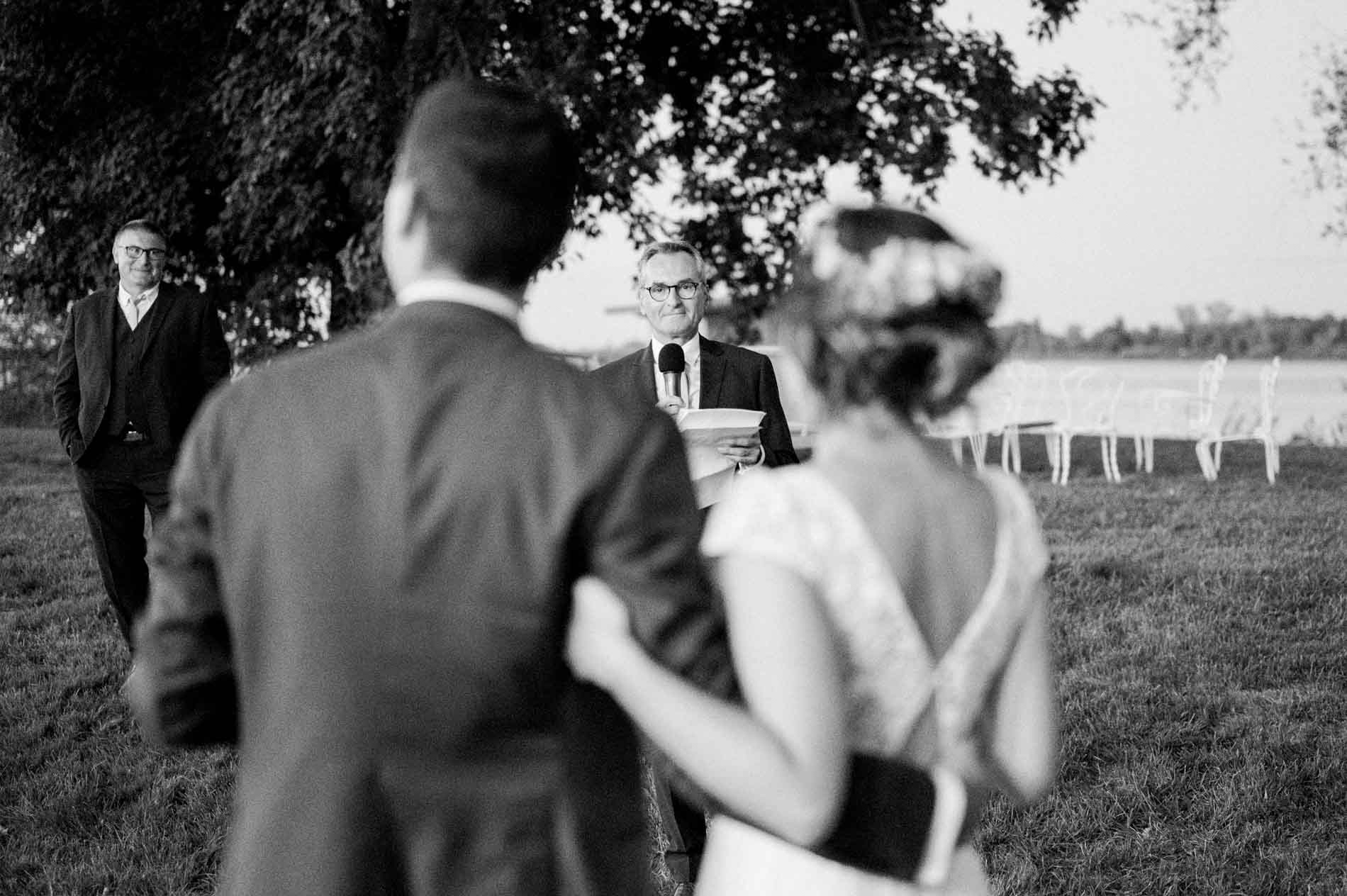 Couple seen from behind listening to the speeches, in black and white