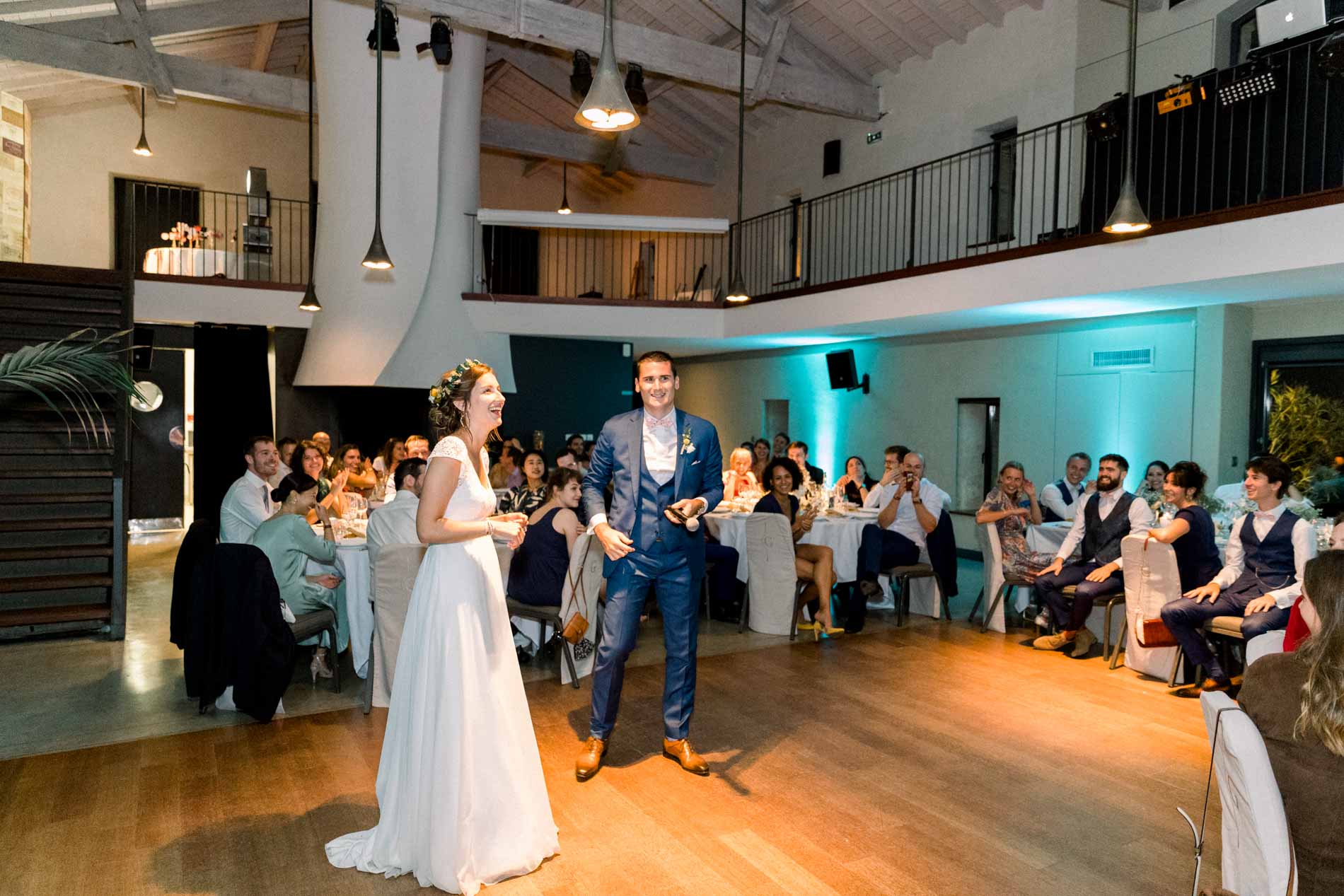 The newlyweds stepping onto the floor for their first dance as guests watch