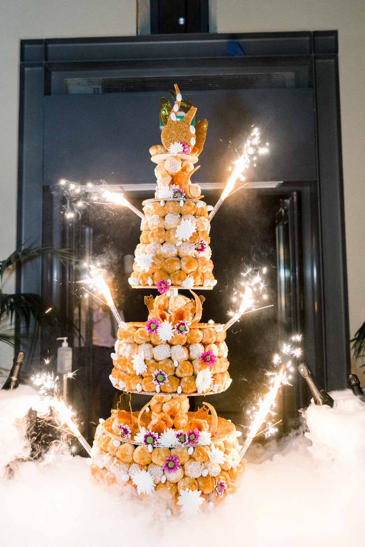 Croquembouche tower lit by sparklers