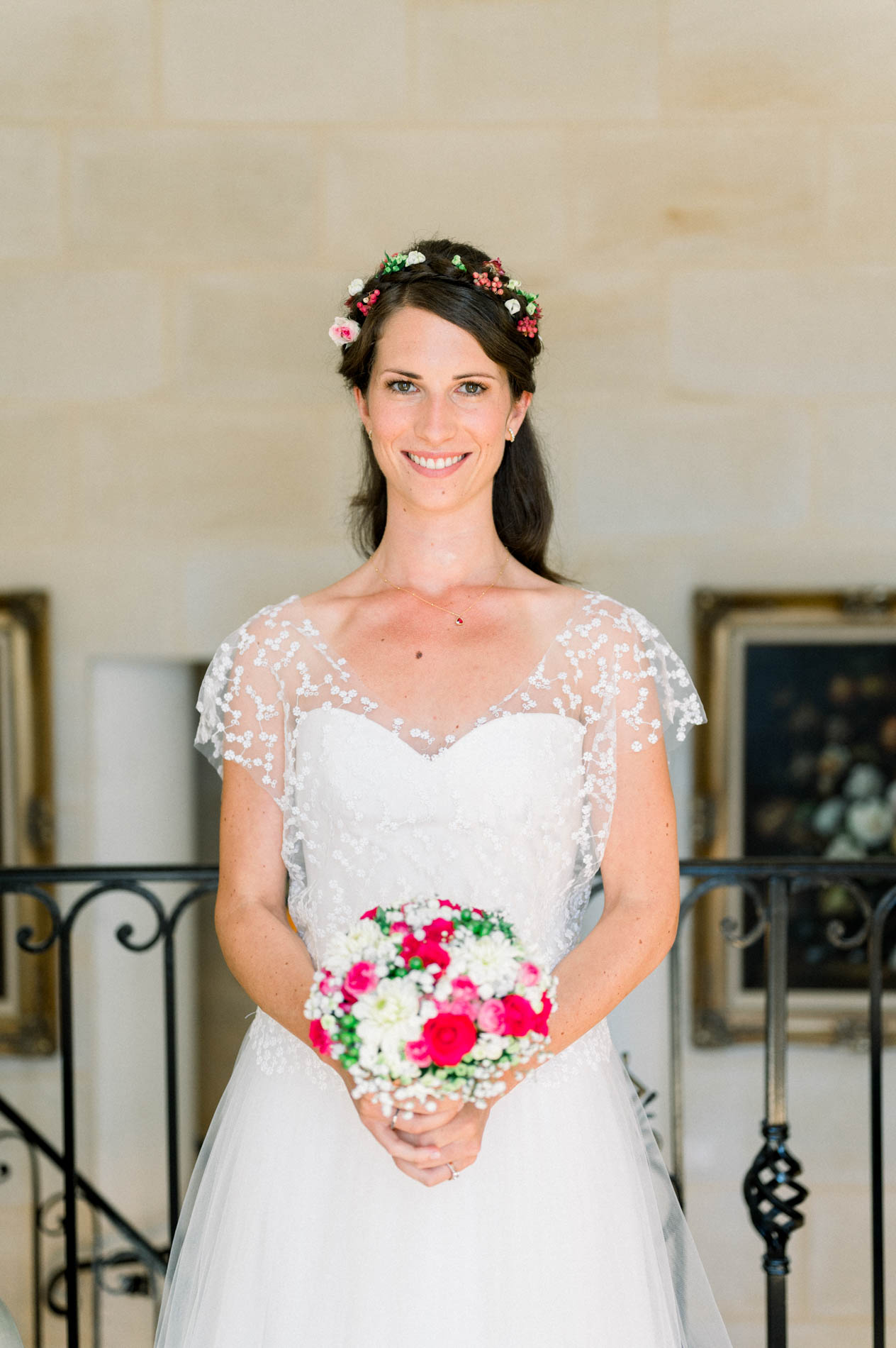 Bride wearing a flower crown and holding a bouquet of red and white roses