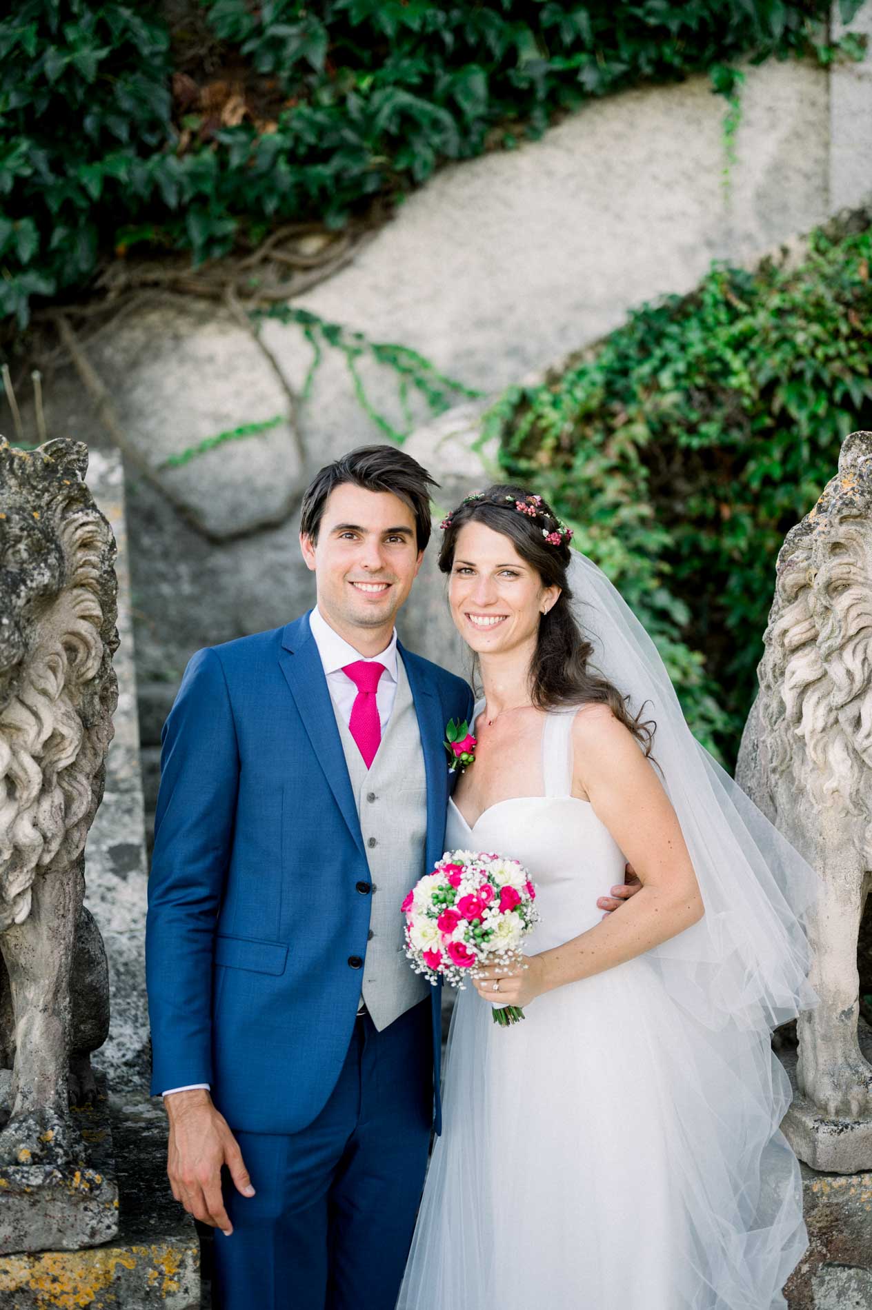 Portrait of the bride and groom by the stone lions and ivy at Château Smith Haut Lafitte