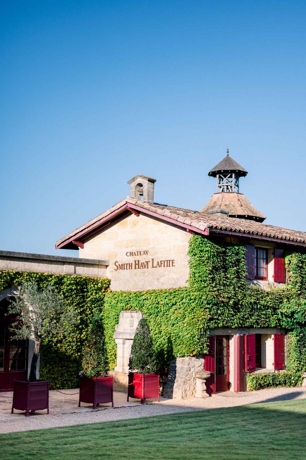 Ivy-covered building bearing the Château Smith Haut Lafitte sign, with its tower