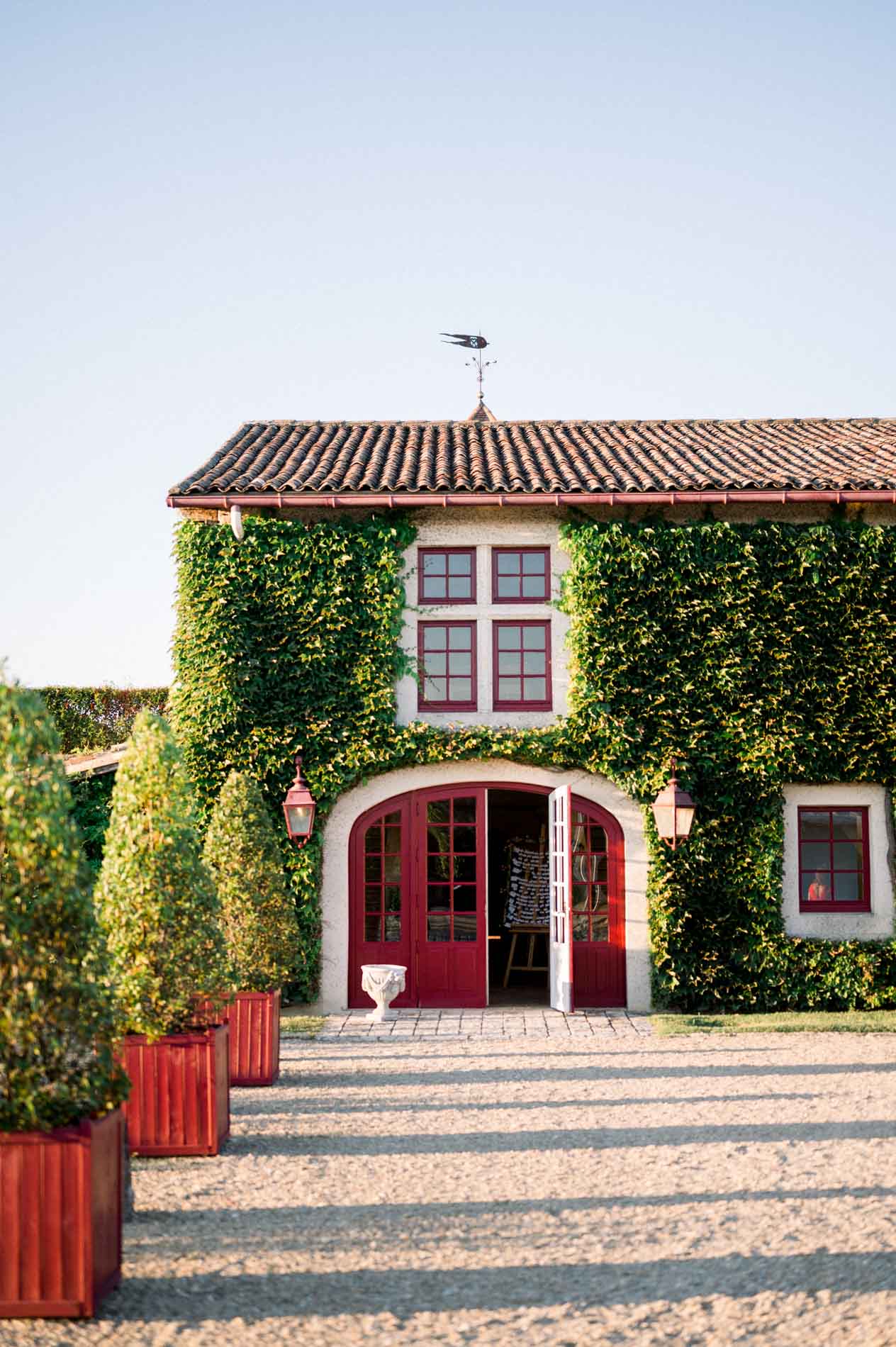 Gravel path leading to the ivy-covered building with its red doors