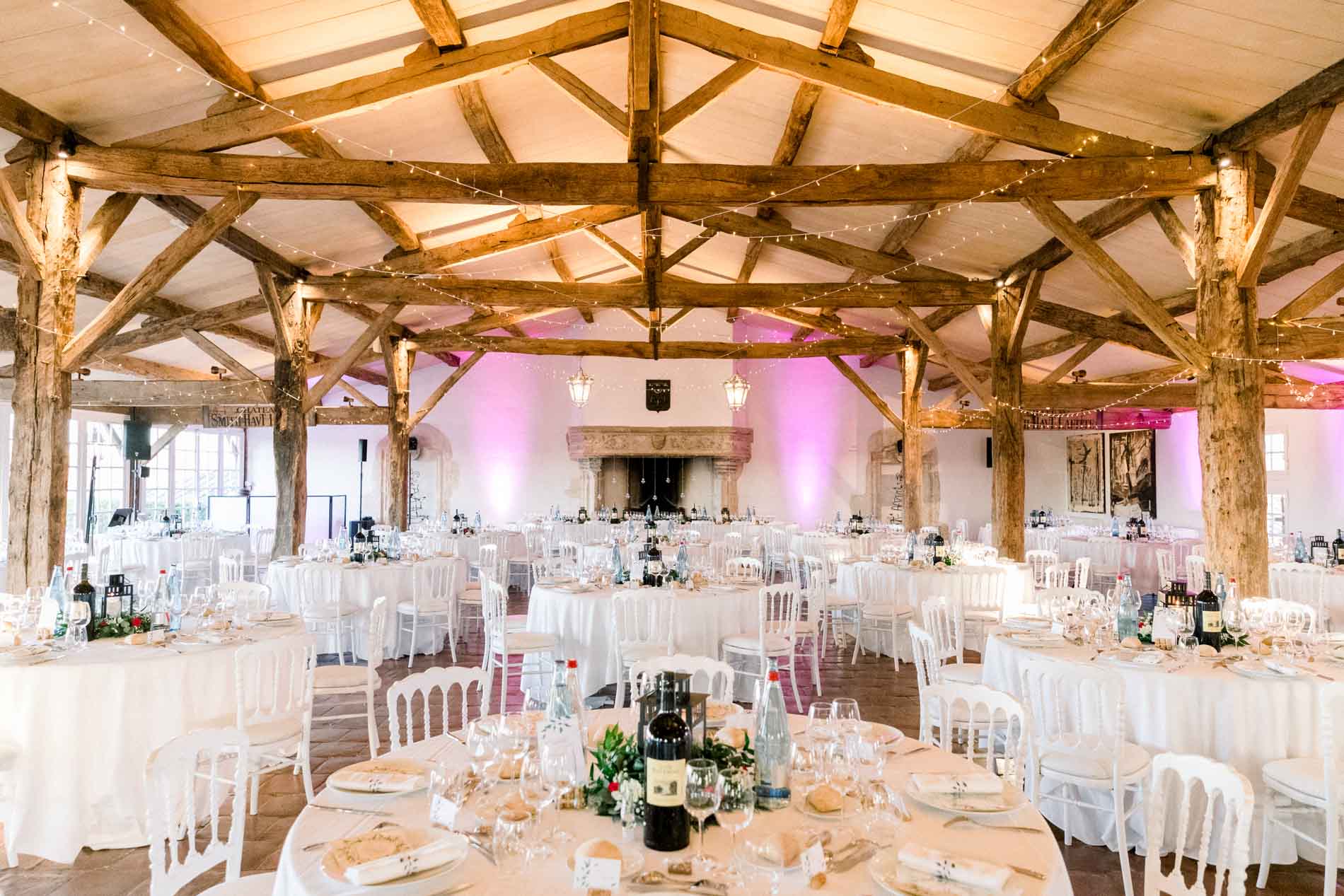 Reception hall with timber beams set with round tables for dinner